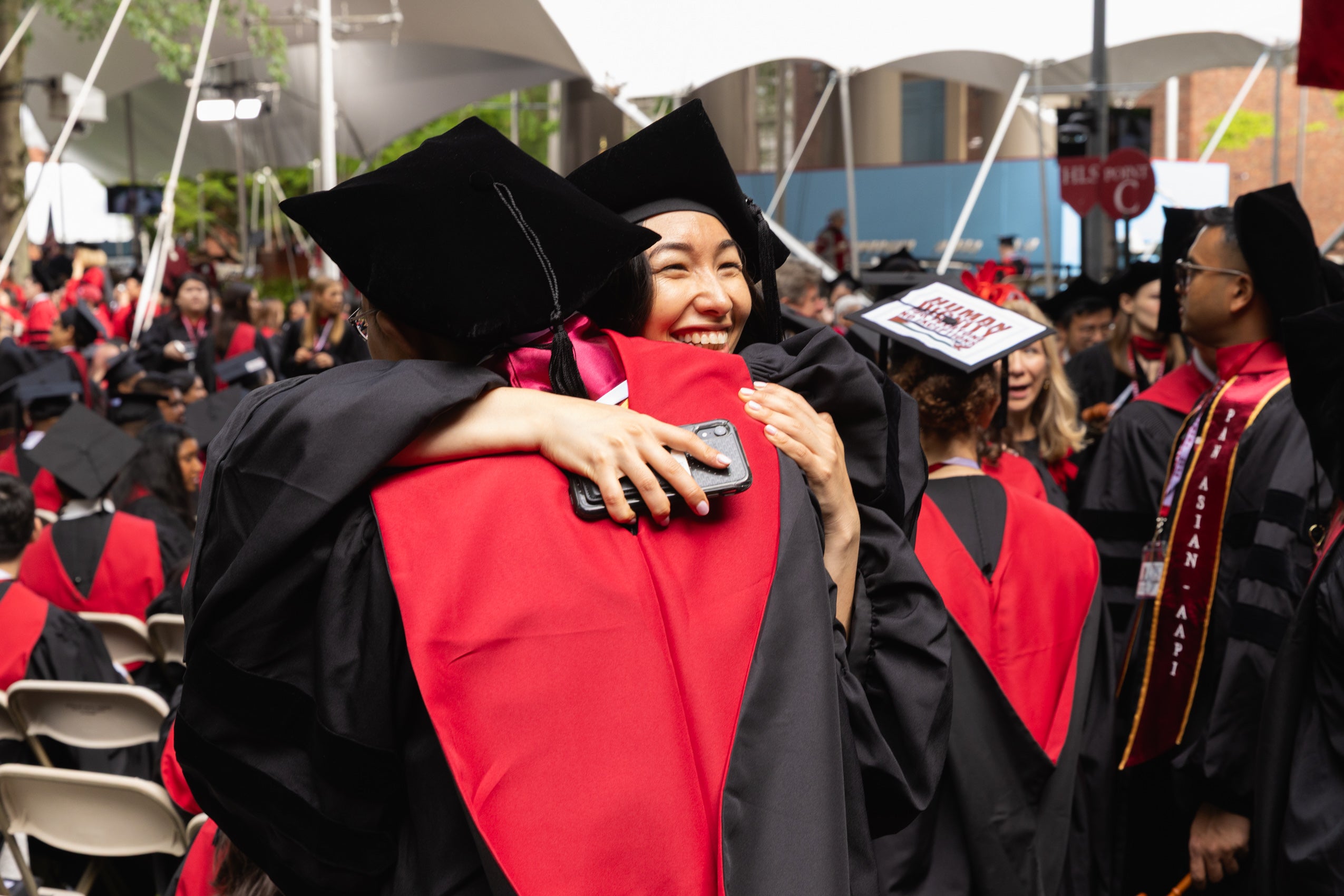Two graduating students hugging