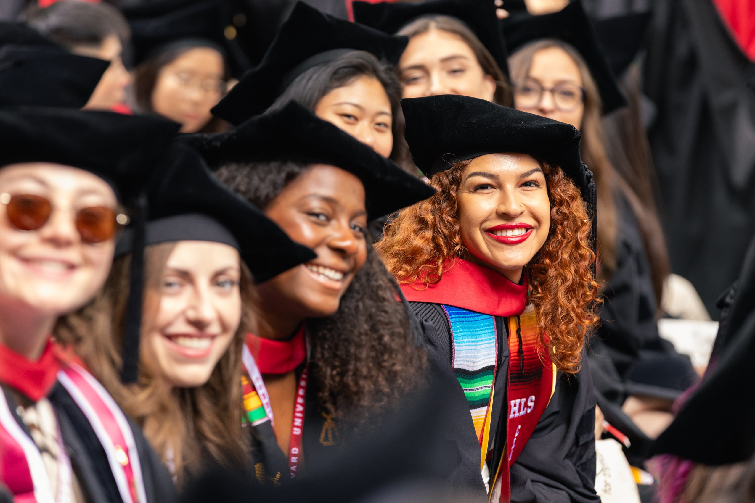 A group of graduated students sitting and smiling