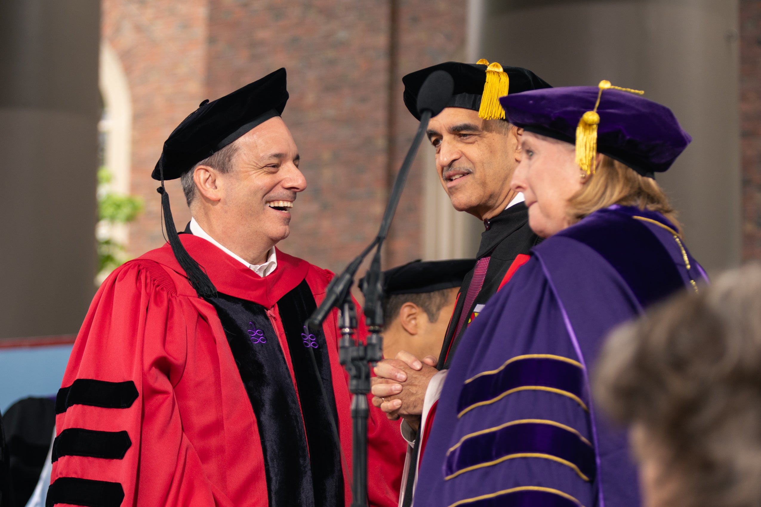 A group of Harvard officials stand together and have a conversation