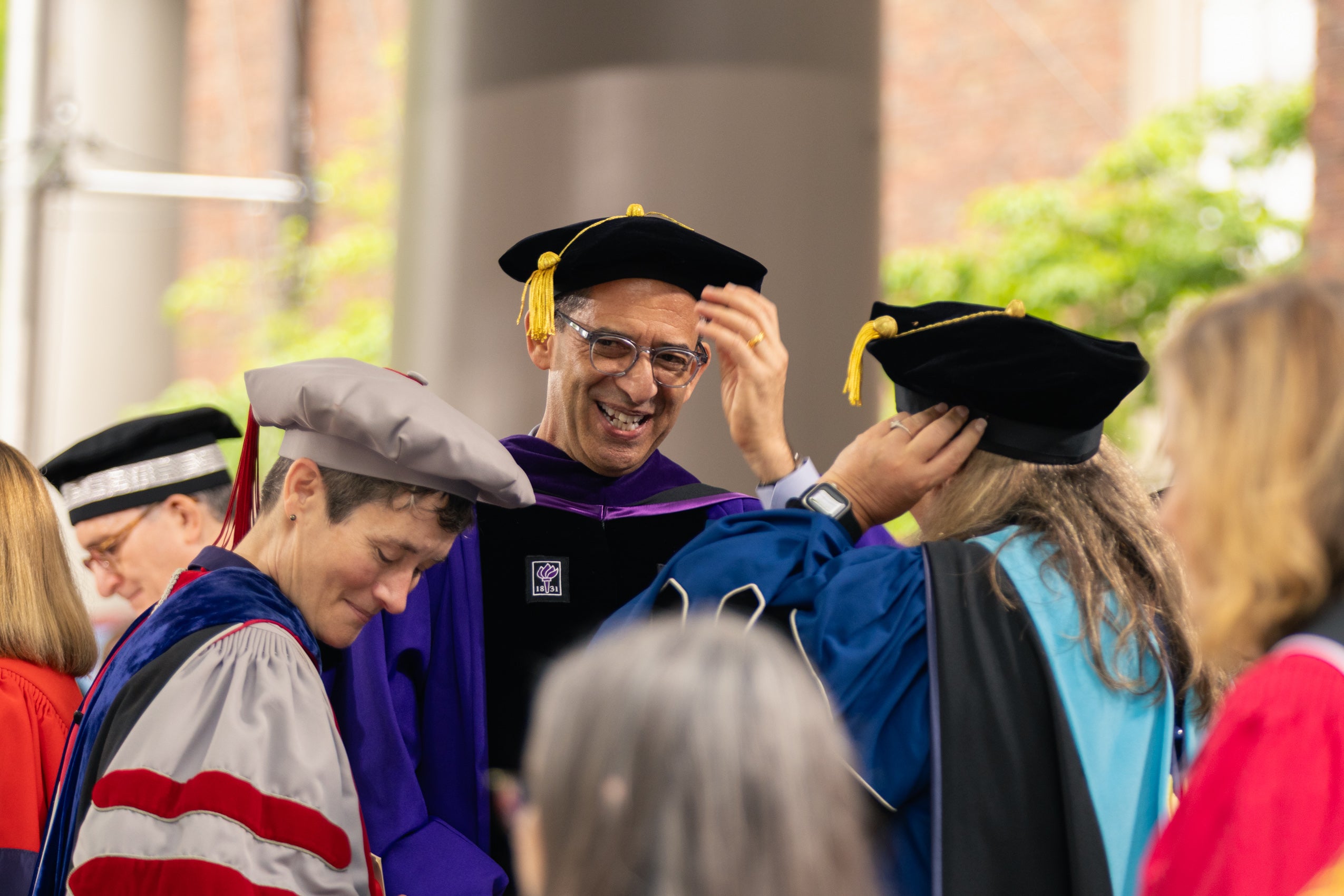 A group of Harvard Deans standing together and chatting