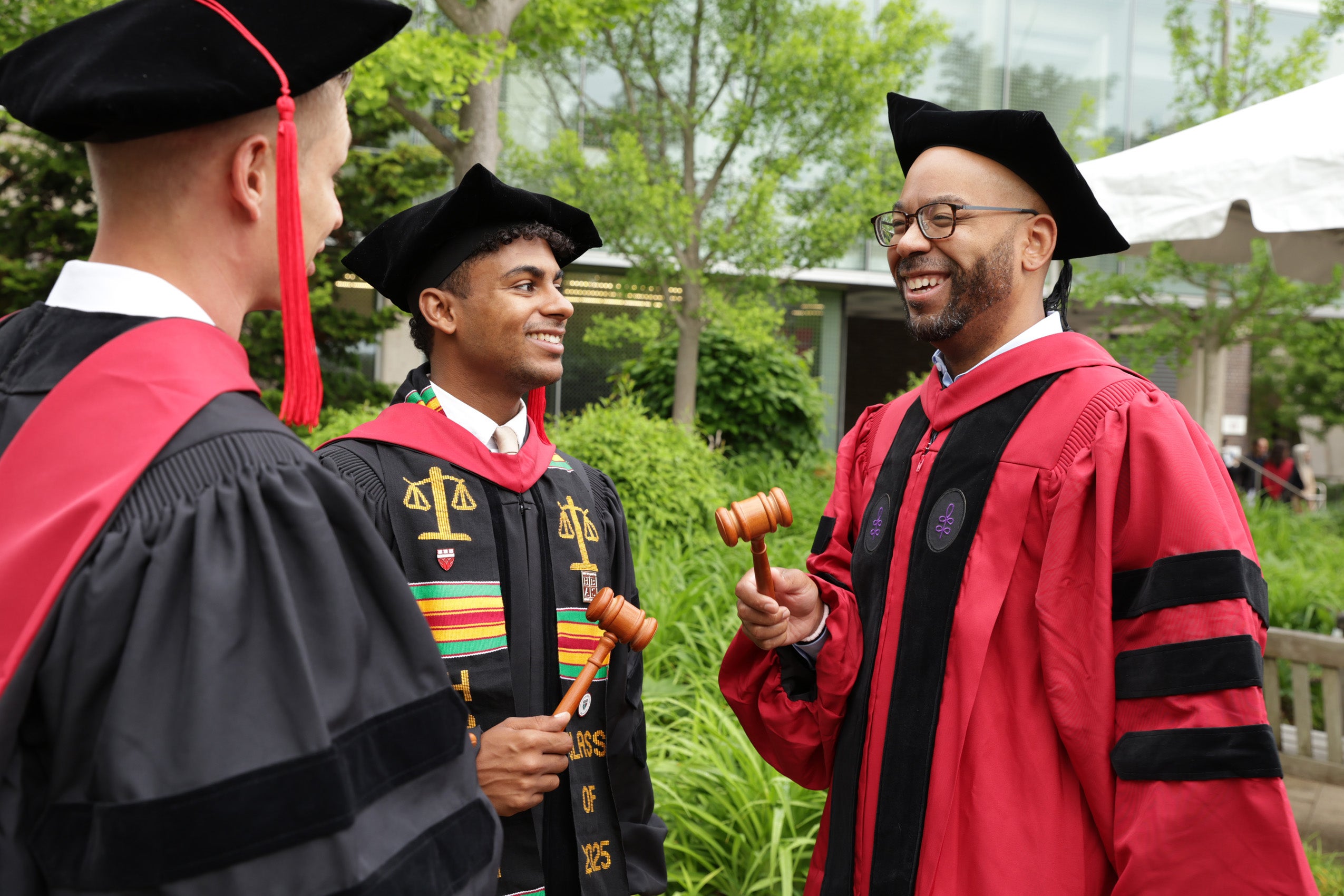 Three men in regalia smiling and chatting