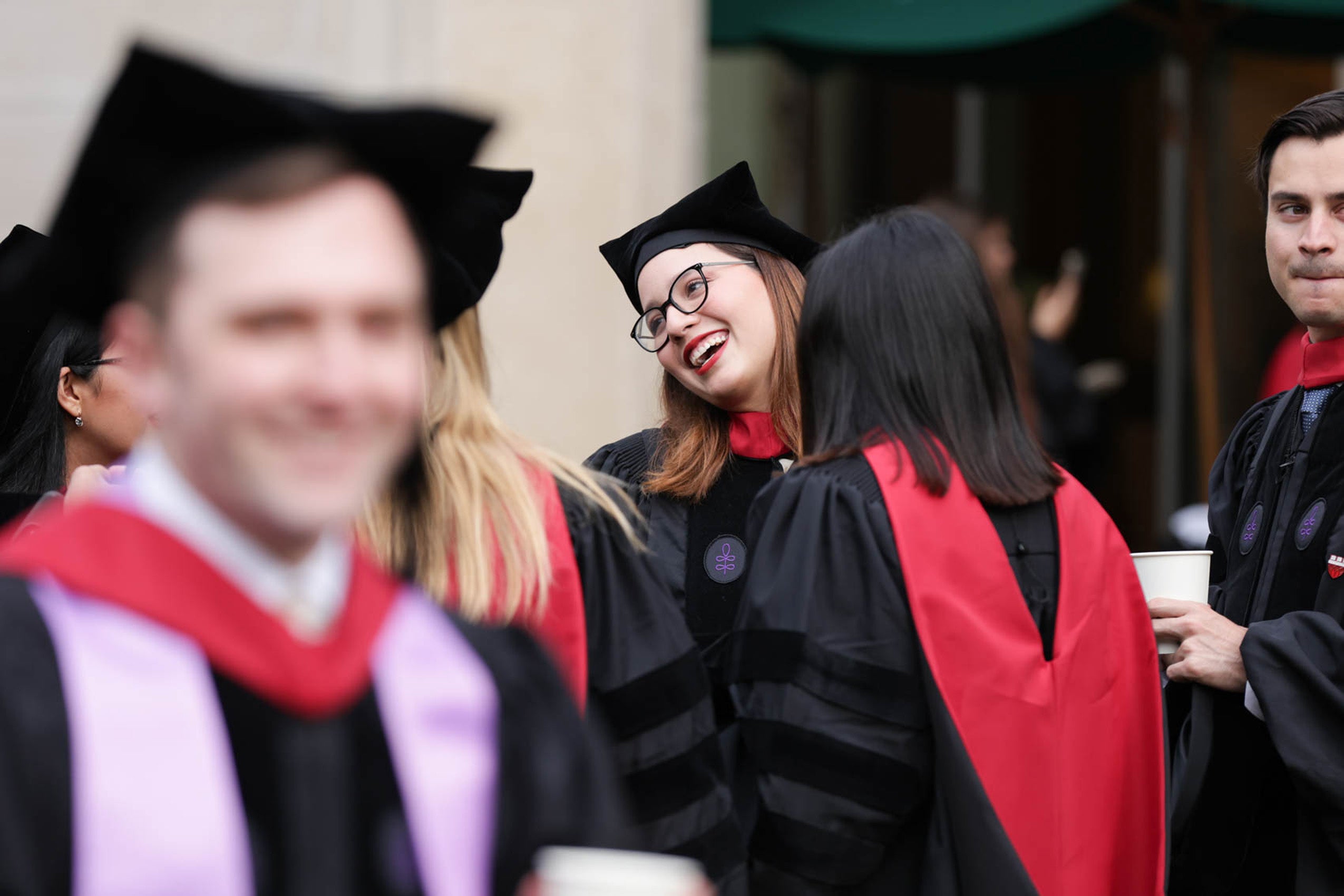 Woman in regalia smiles and converses