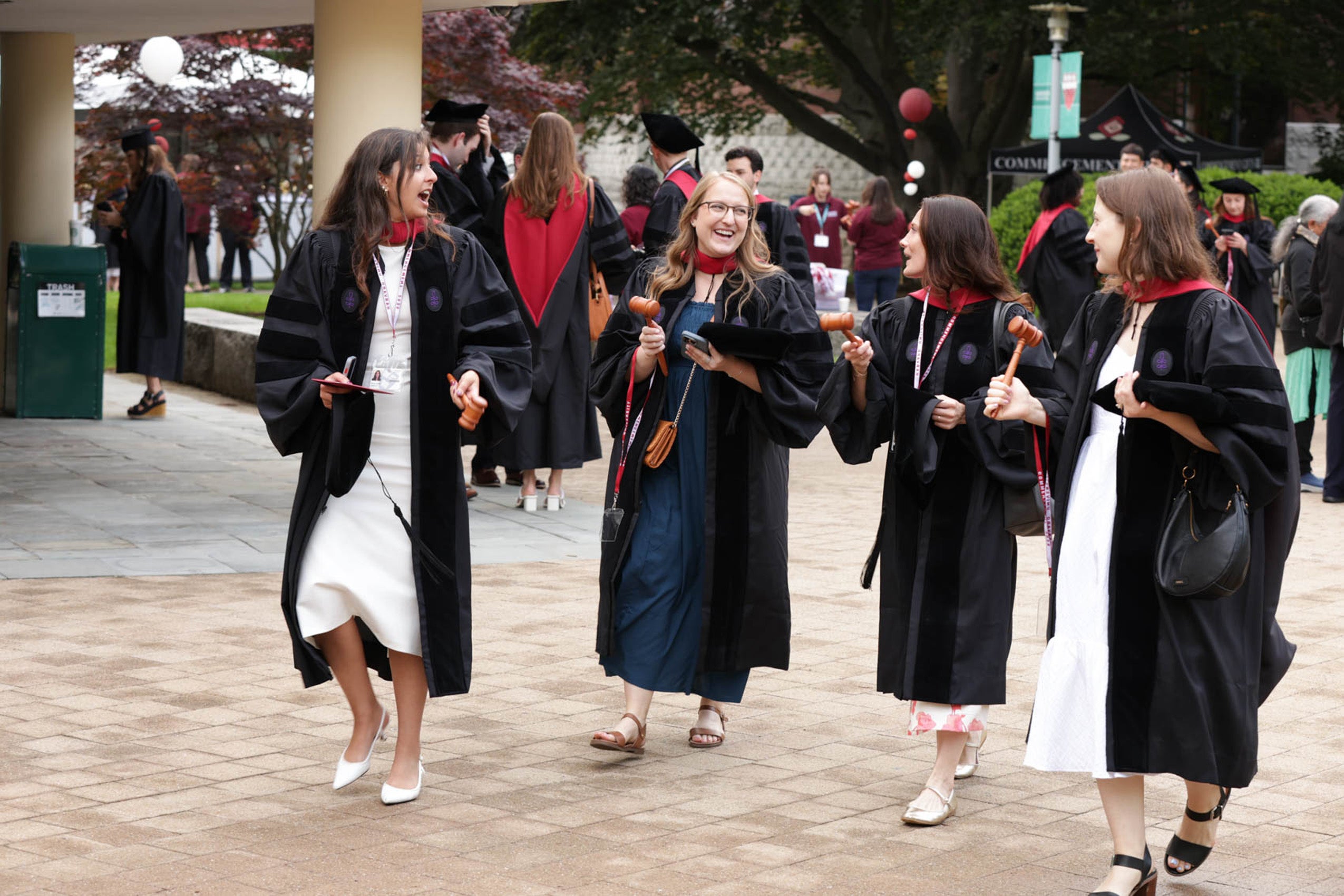 A group of four women in regalia chatting and walking together