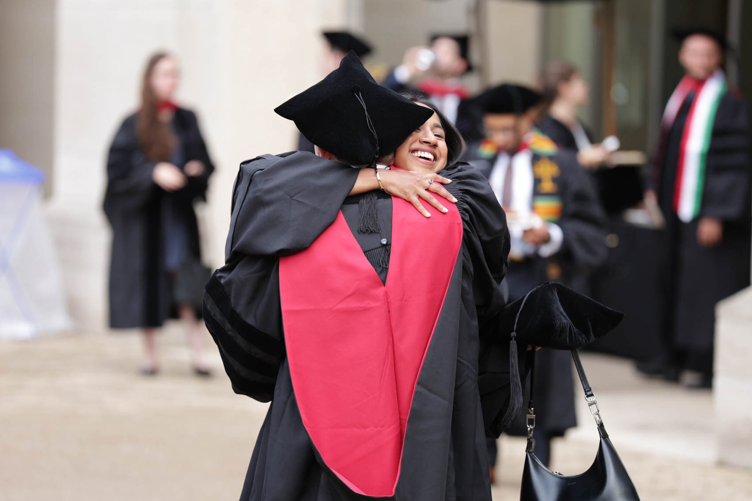 Women in regalia hug