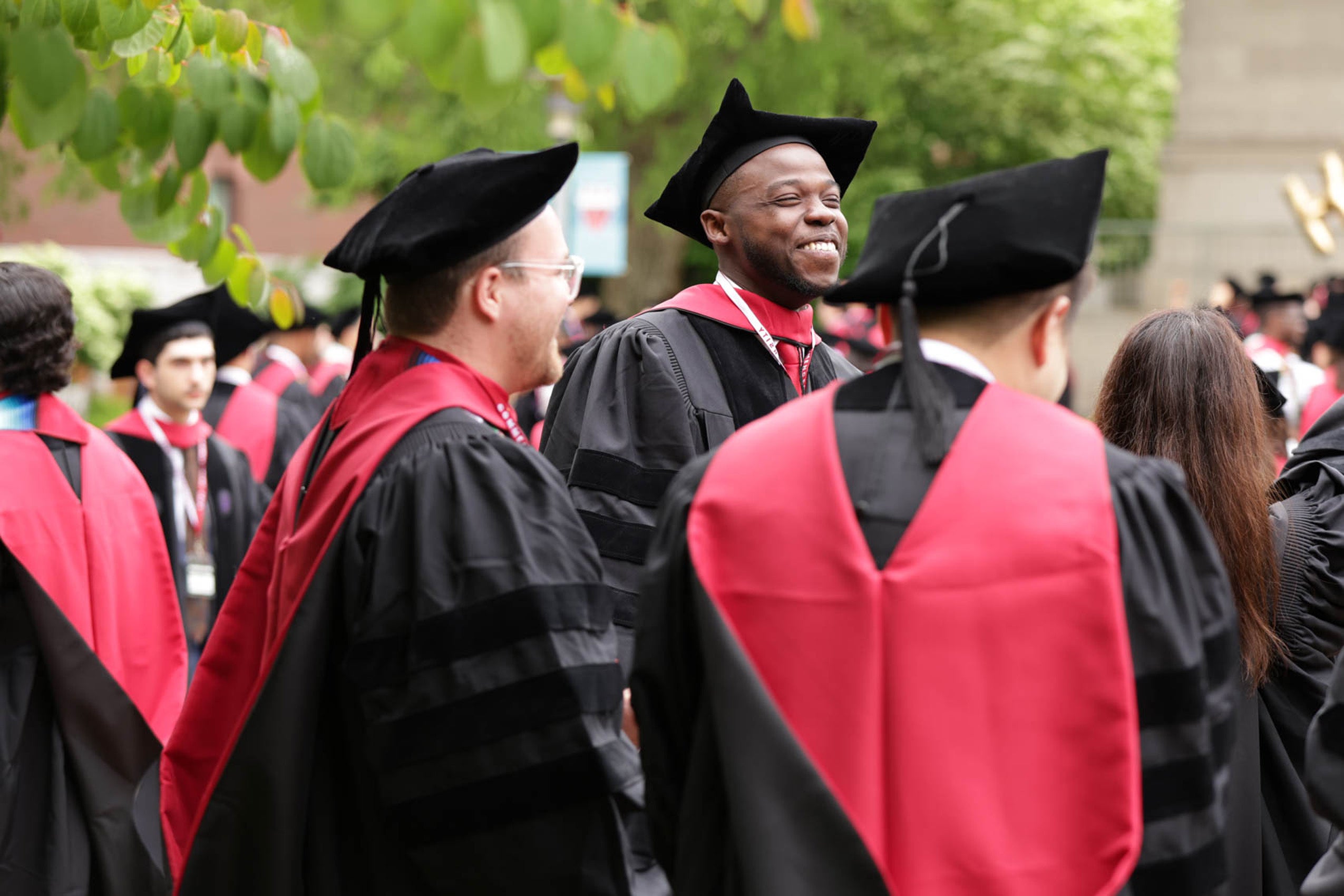 Man smiles among crowd of graduates