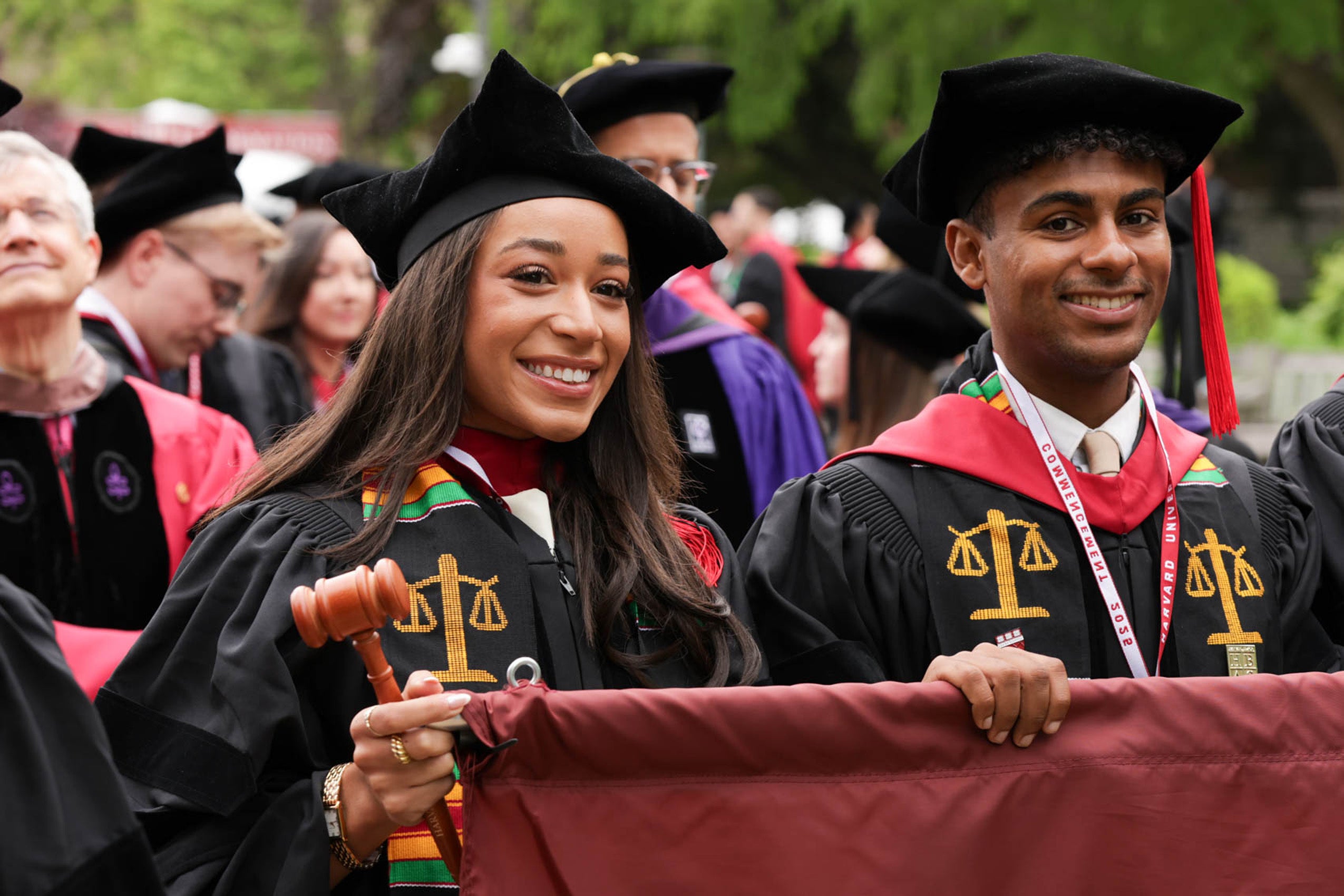 Two smiling students lead commencement procession