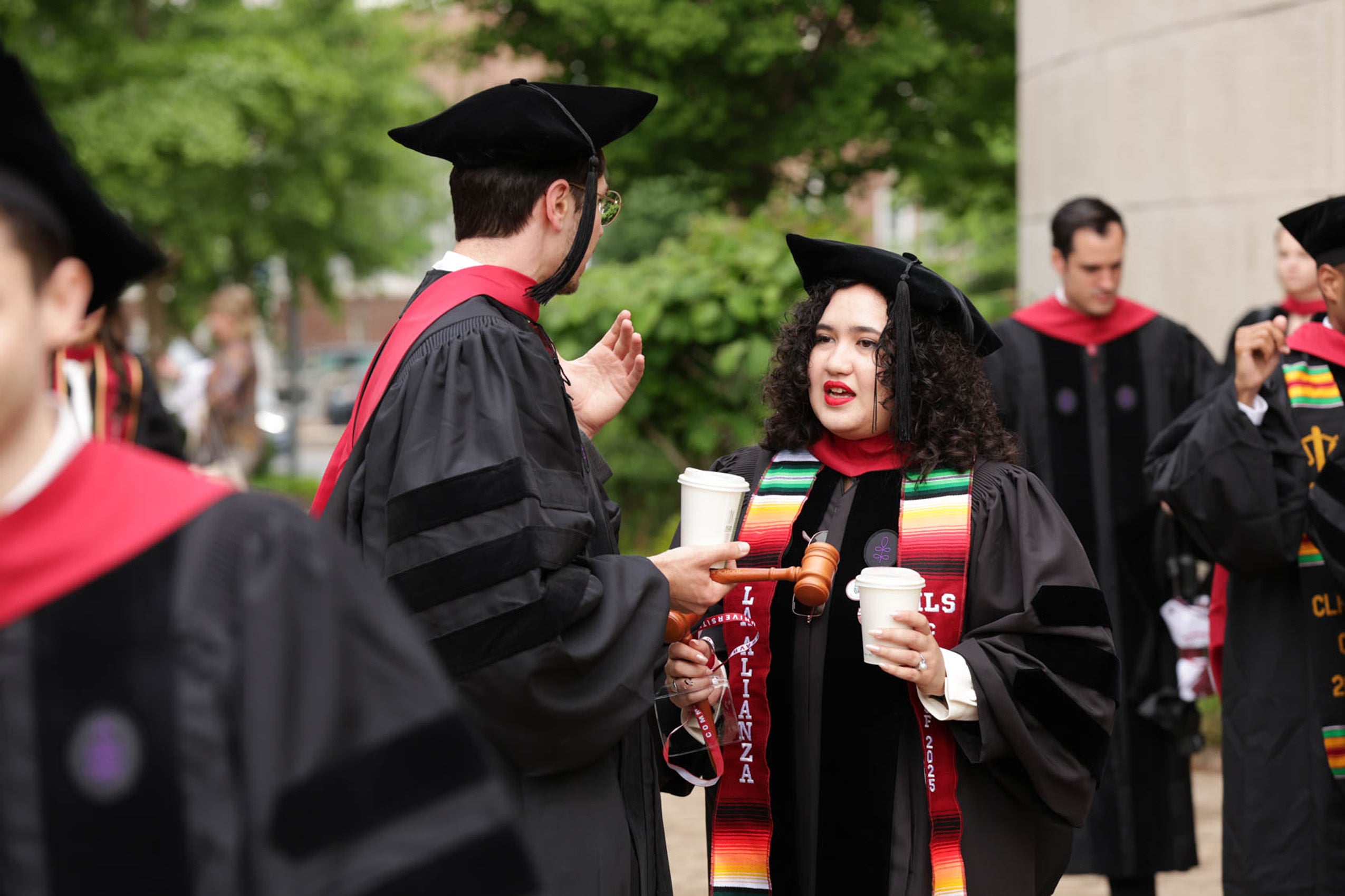 People in regalia converse