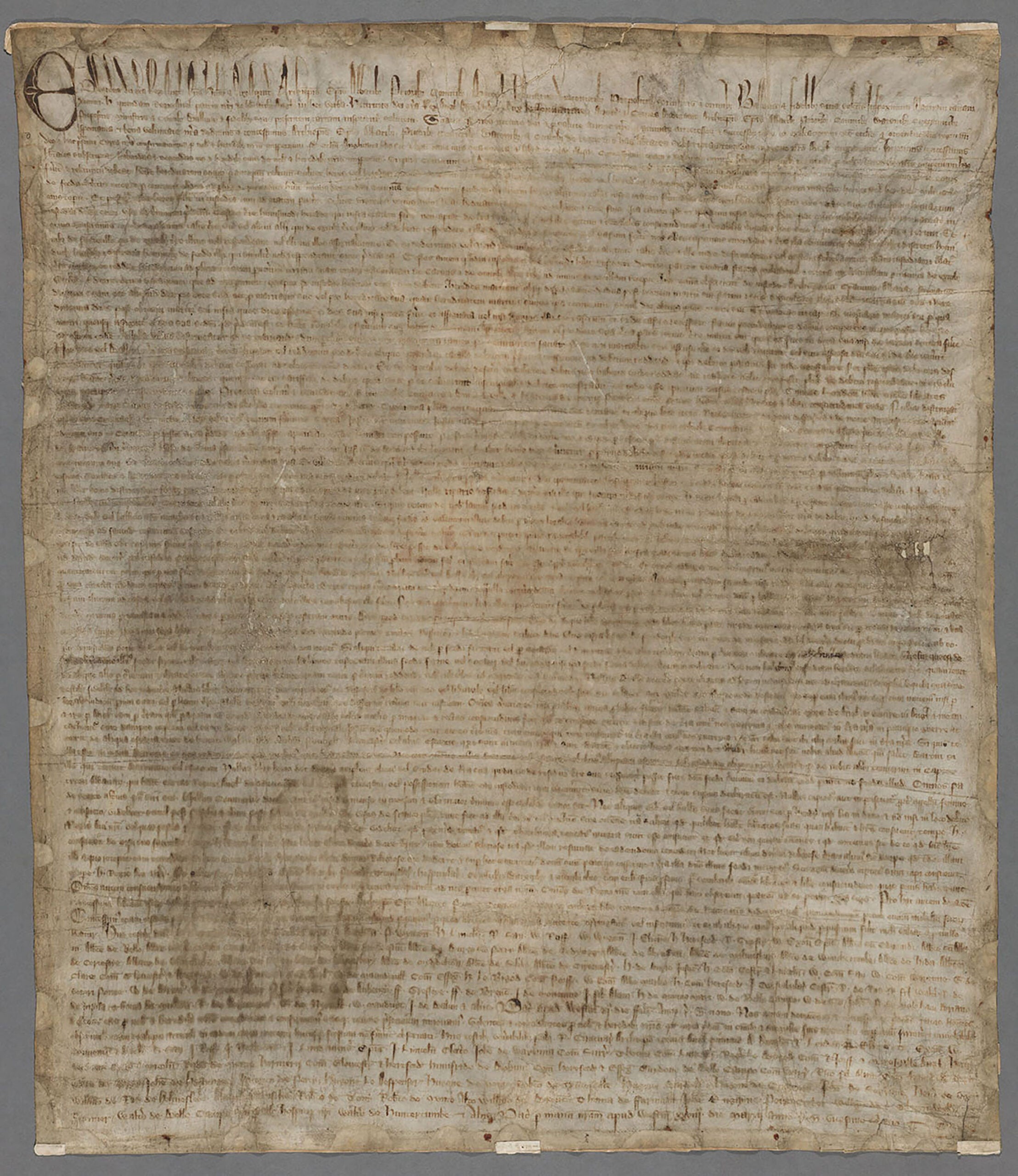 Manuscript Magna Carta on a single vellum sheet, faded text written in a close, dense hand.