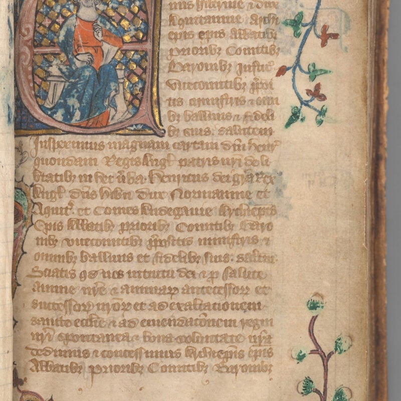 Start of manuscript Magna Carta on vellum with an illuminated initial of King Edward II before a gold and blue checkered background.