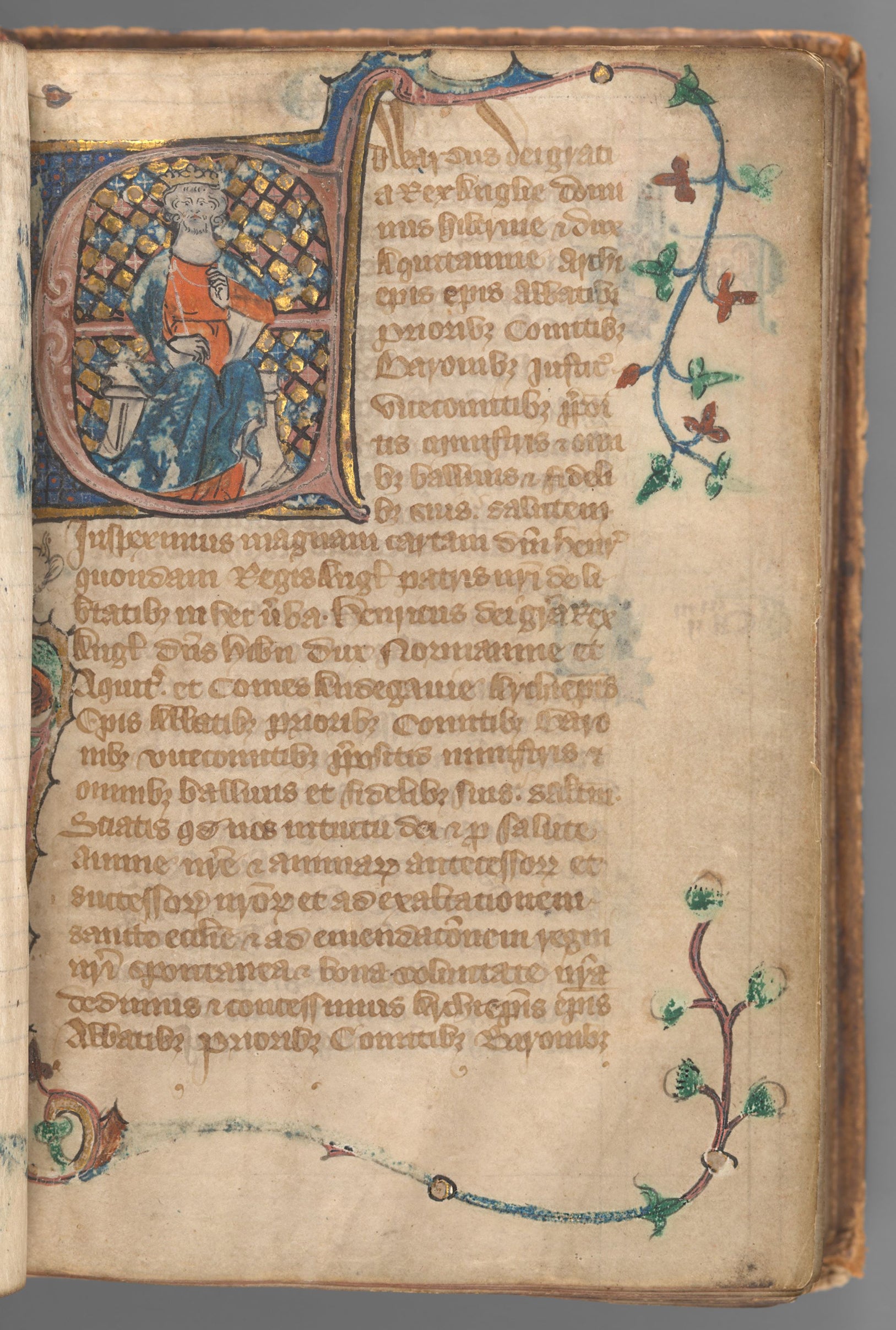 Start of manuscript Magna Carta on vellum with an illuminated initial of King Edward II before a gold and blue checkered background.