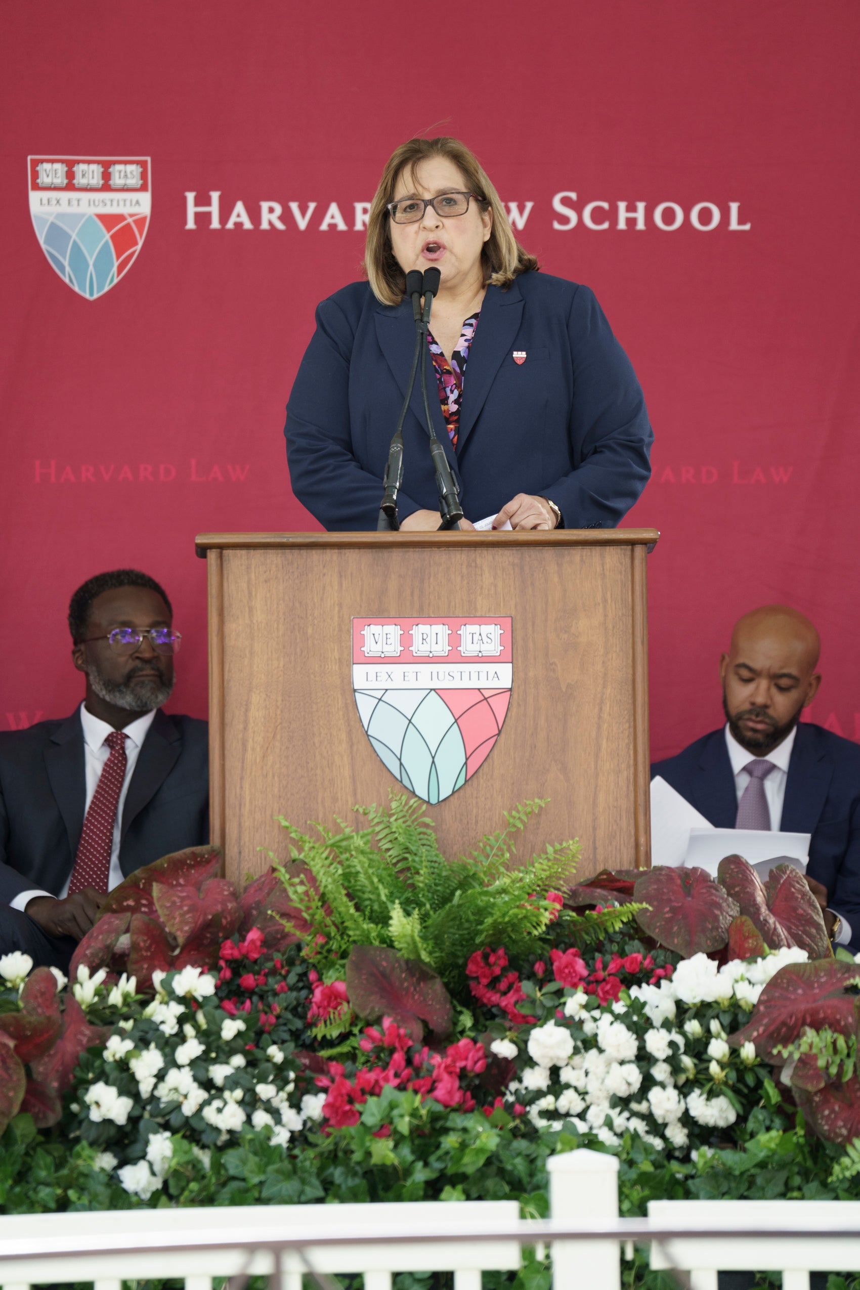 A woman standing and speaking at a podium