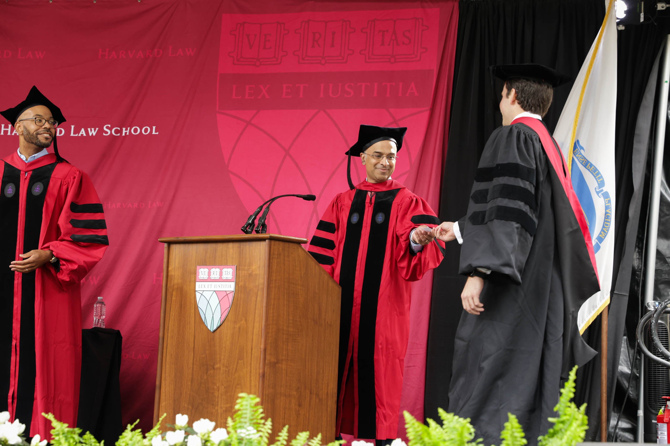 A graduate walks across the stage to receive his diploma.