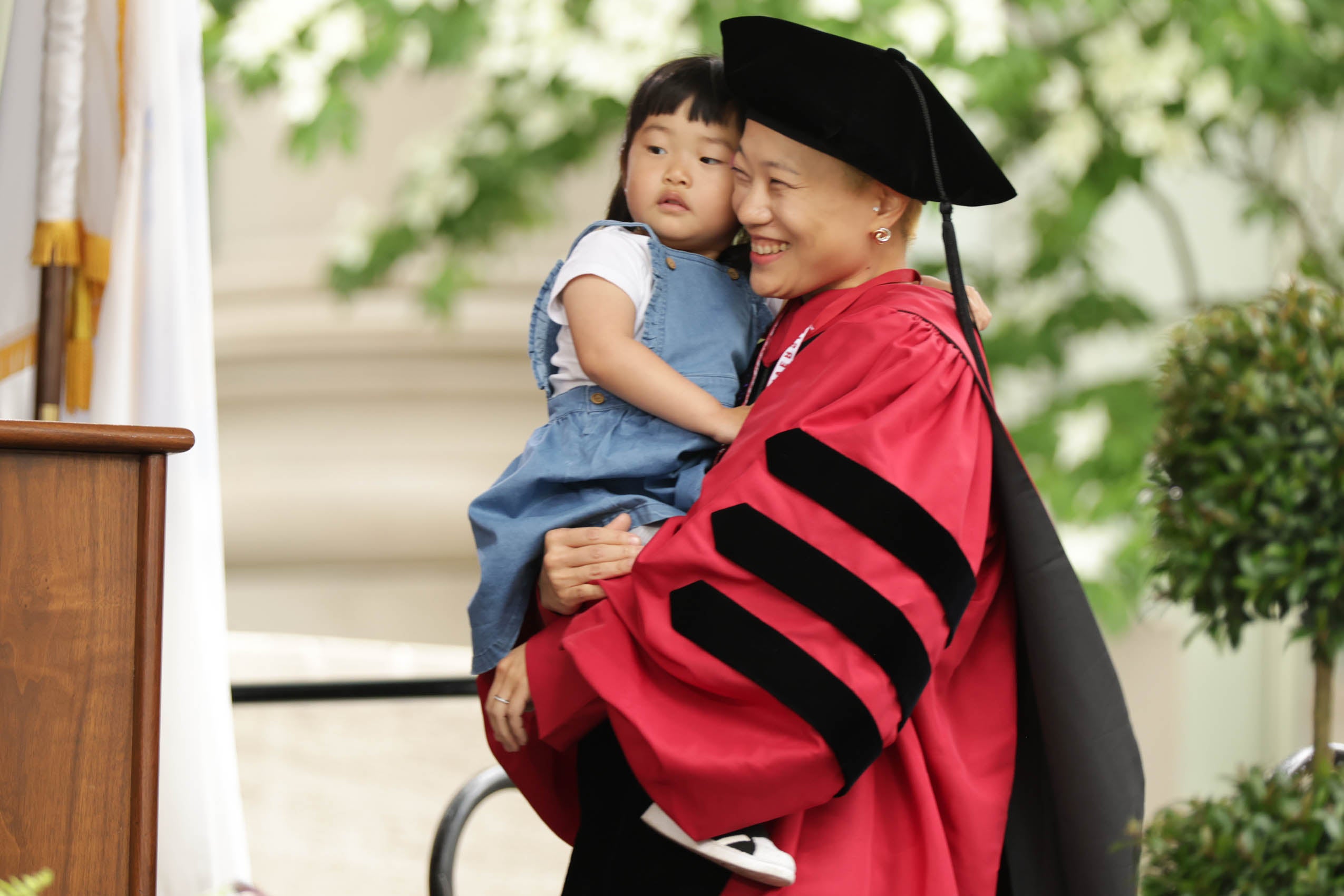 A graduate holding her child