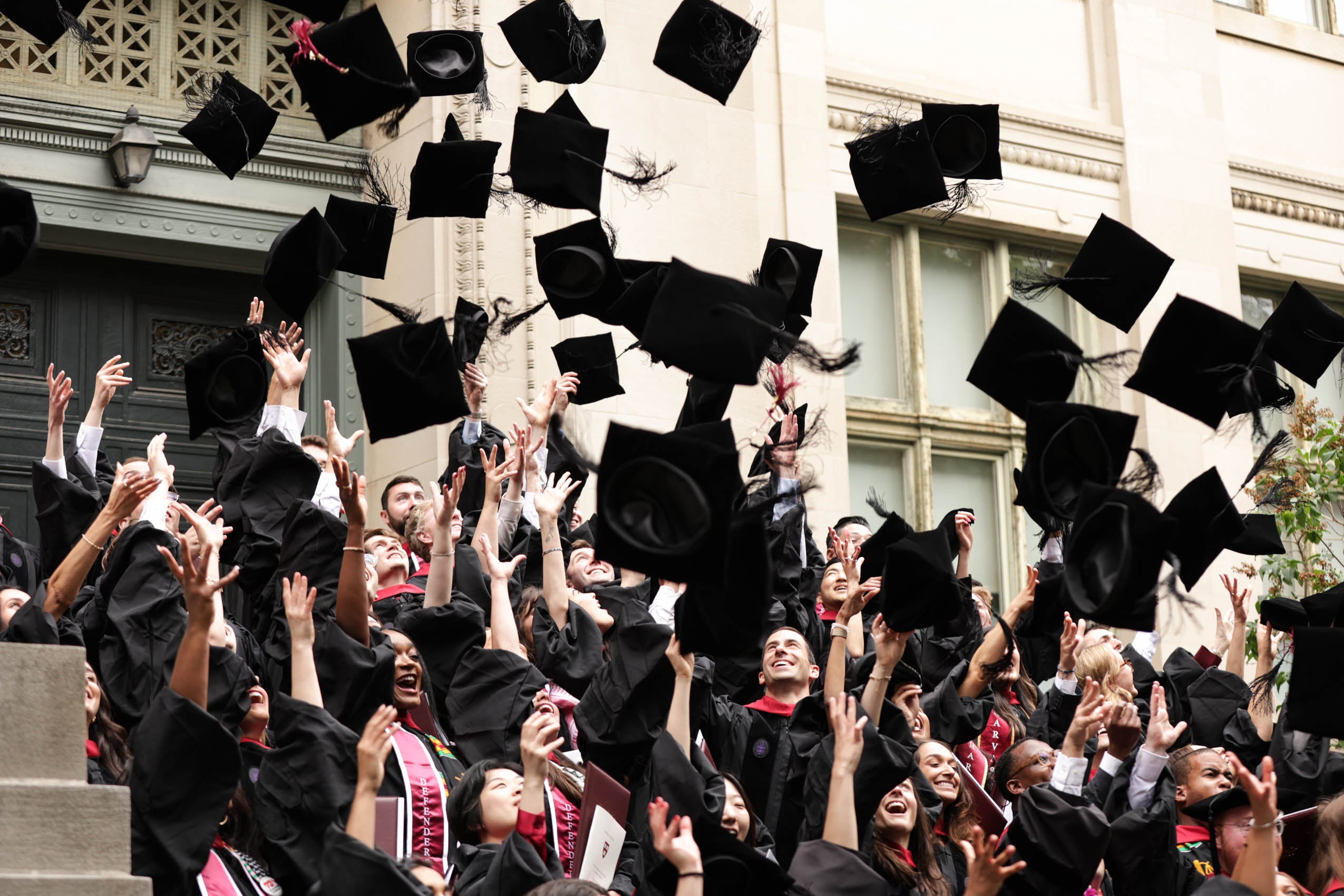 Graduates tossing their grad caps into the air