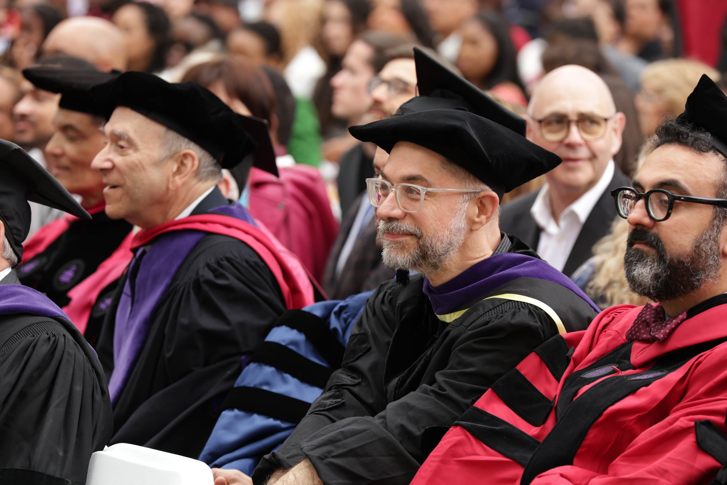 Faculty sitting and listening to the program