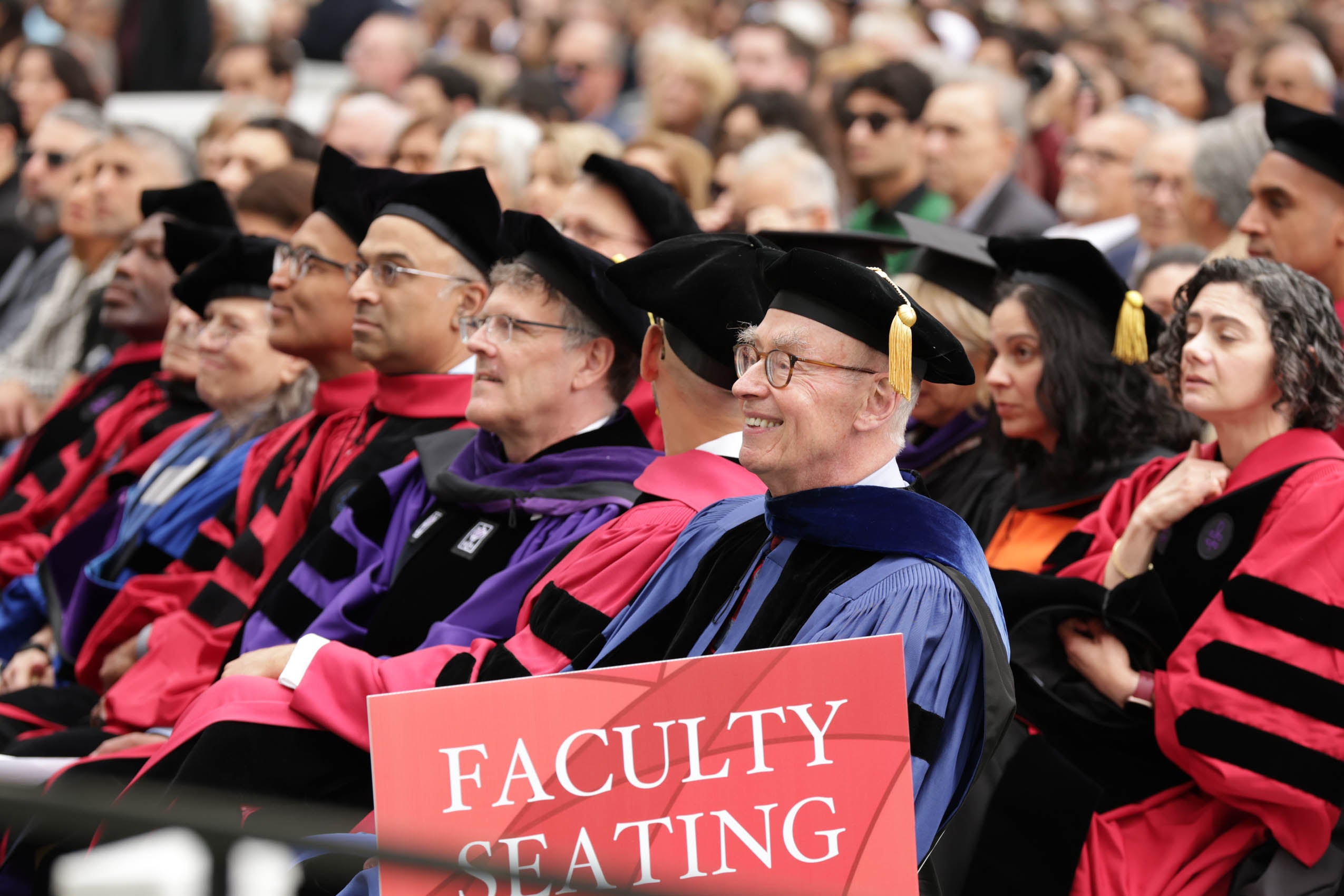 Faculty sitting and listening to the program