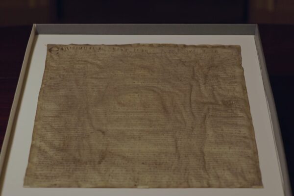 Magna Carta on display atop a framed mat.