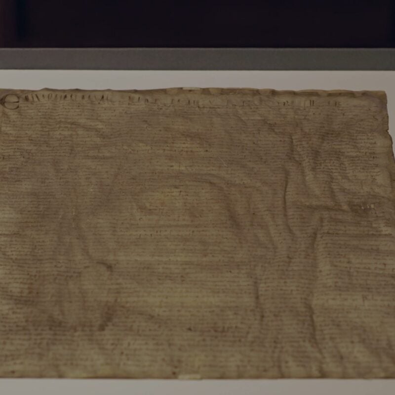 Magna Carta on display atop a framed mat.