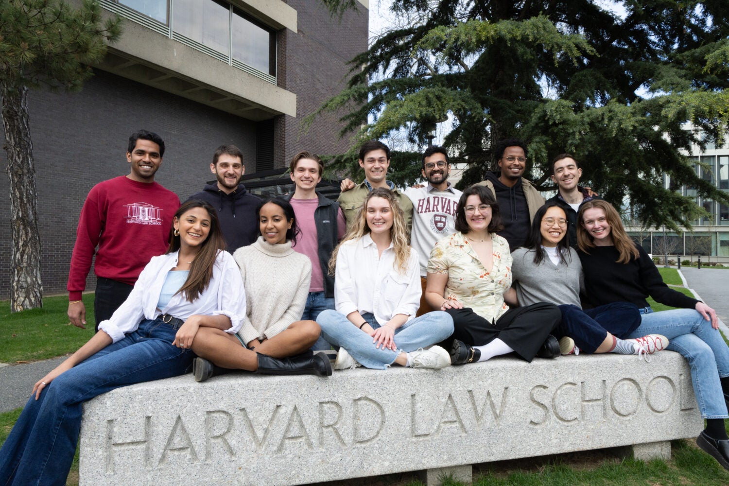 A group of HLS students sitting on a sign that says
