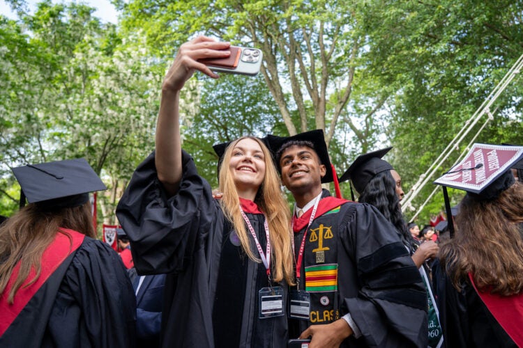 Two graduates taking a selfie.