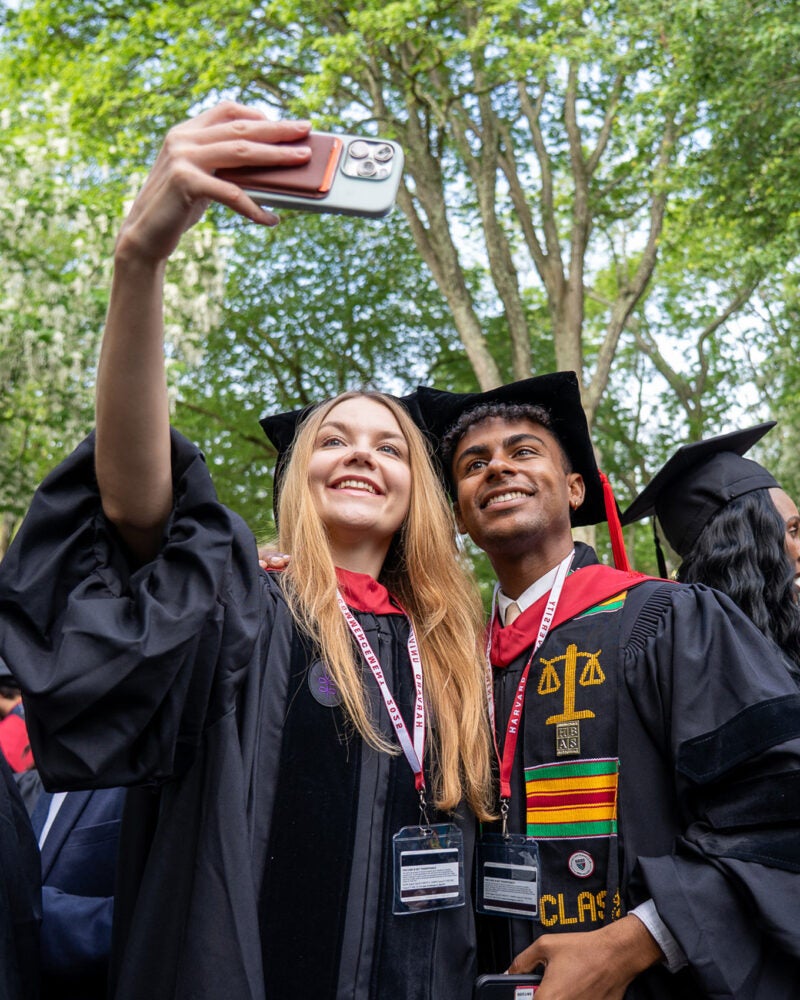 Two graduates taking a selfie.