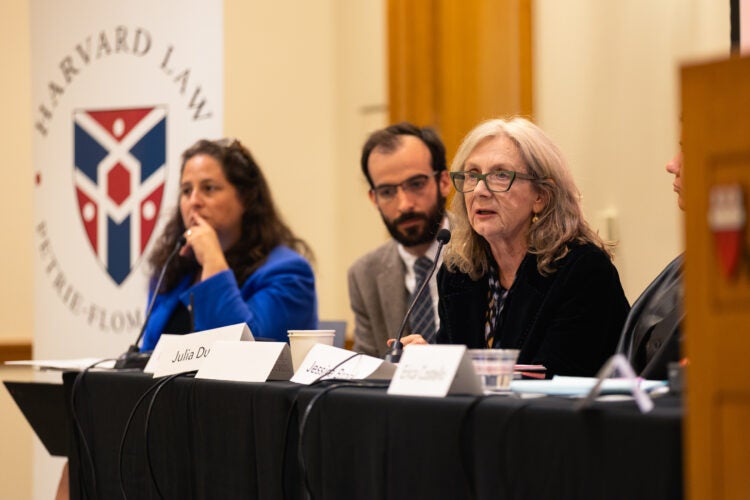Three panelists seated at a table.