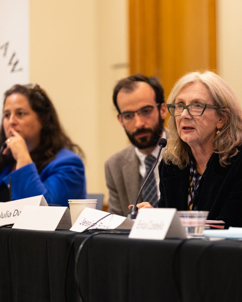 Three panelists seated at a table.