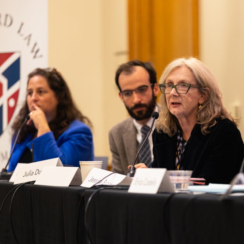 Three panelists seated at a table.