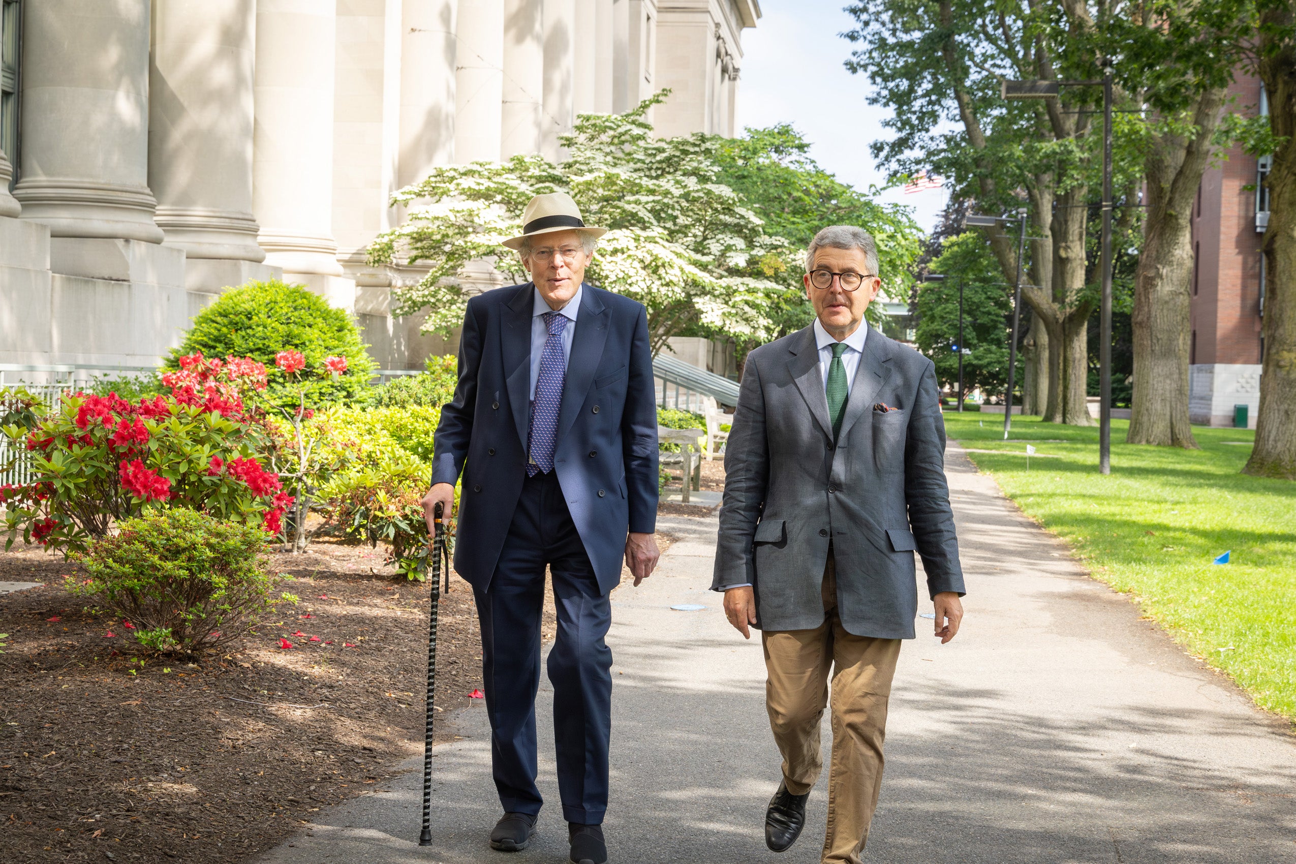 Two men walking along a path on HLS campus.