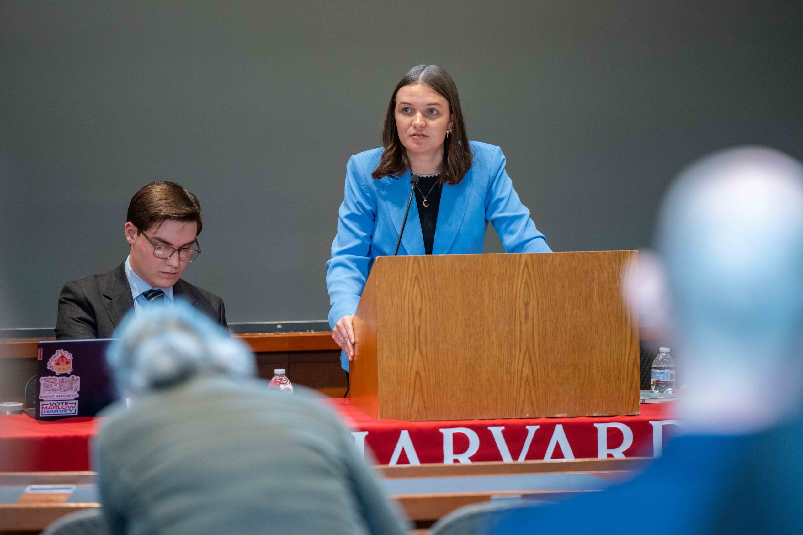 A member of Mock Collegiate Interteam Debate team speaks at a podium.