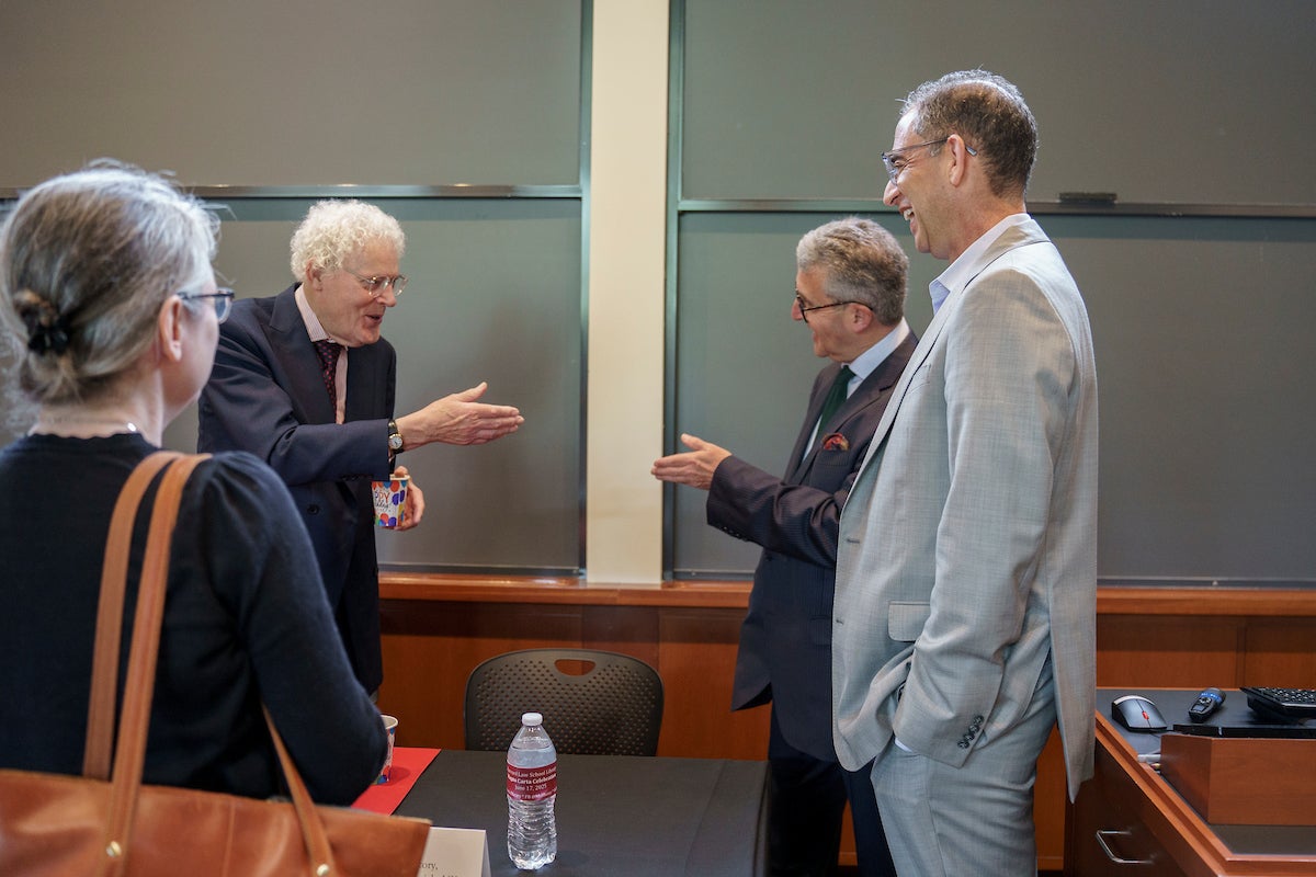 British researchers chat with John Goldberg in a classroom.