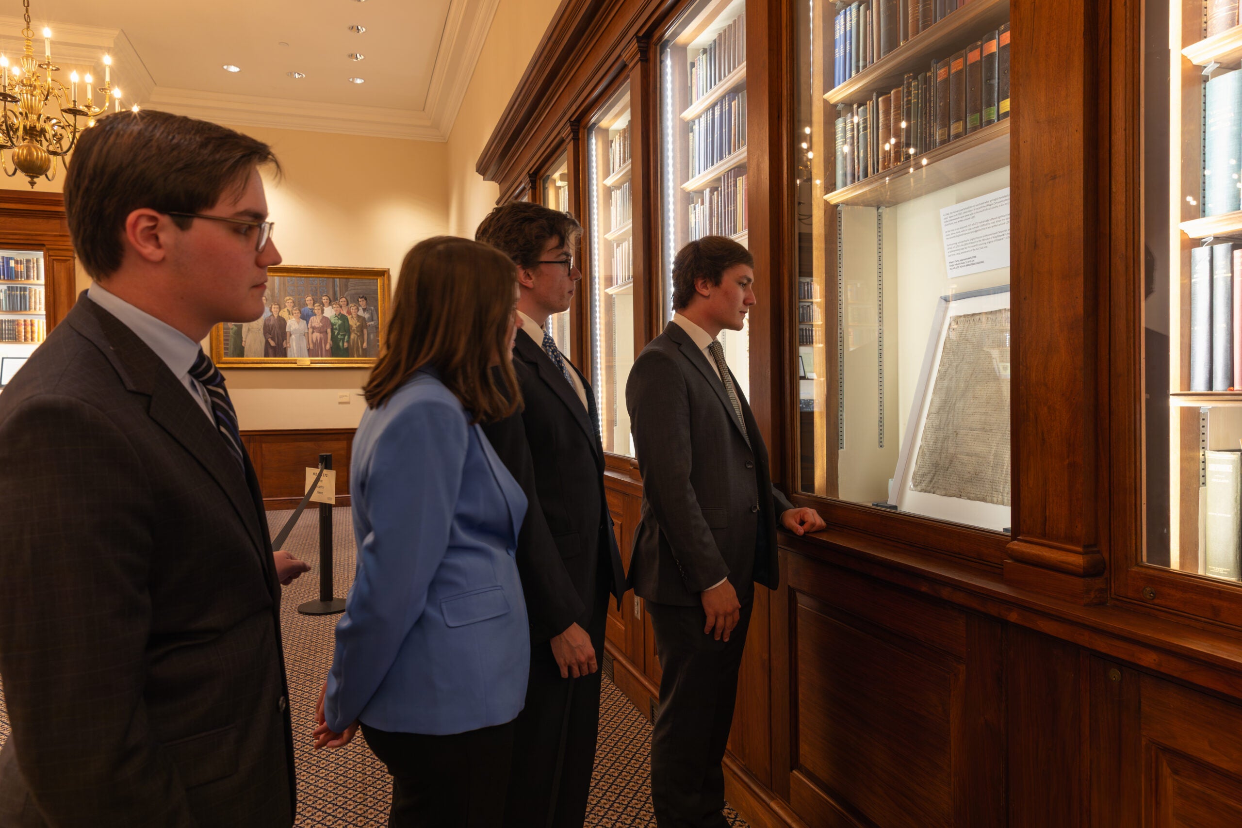 Members of a collegiate debate team view the Magna Carta in the Caspersen Room.
