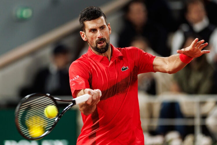 Novak Djokovic hitting a tennis ball.