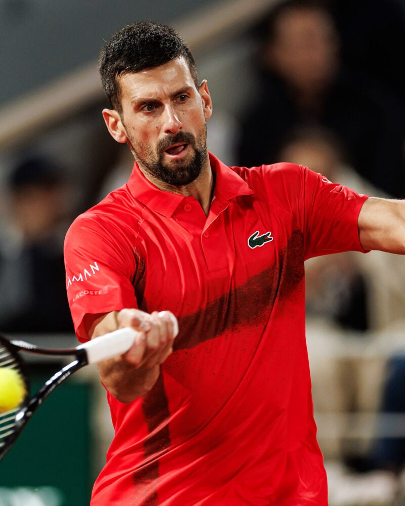 Novak Djokovic hitting a tennis ball.