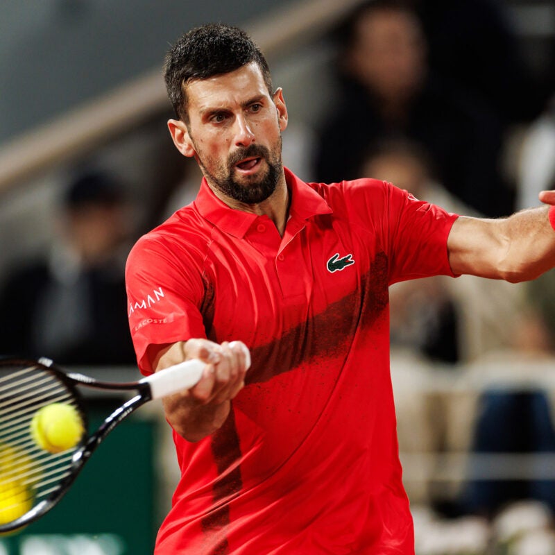 Novak Djokovic hitting a tennis ball.