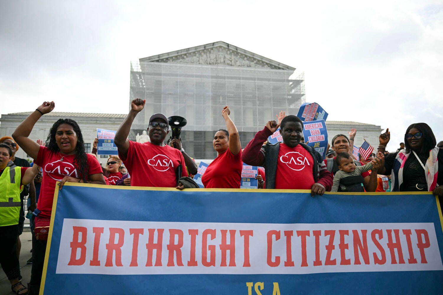 People holding a banner outside the Supreme Court.