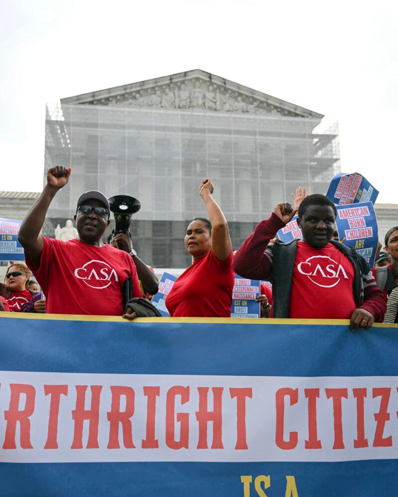 People holding a banner outside the Supreme Court.