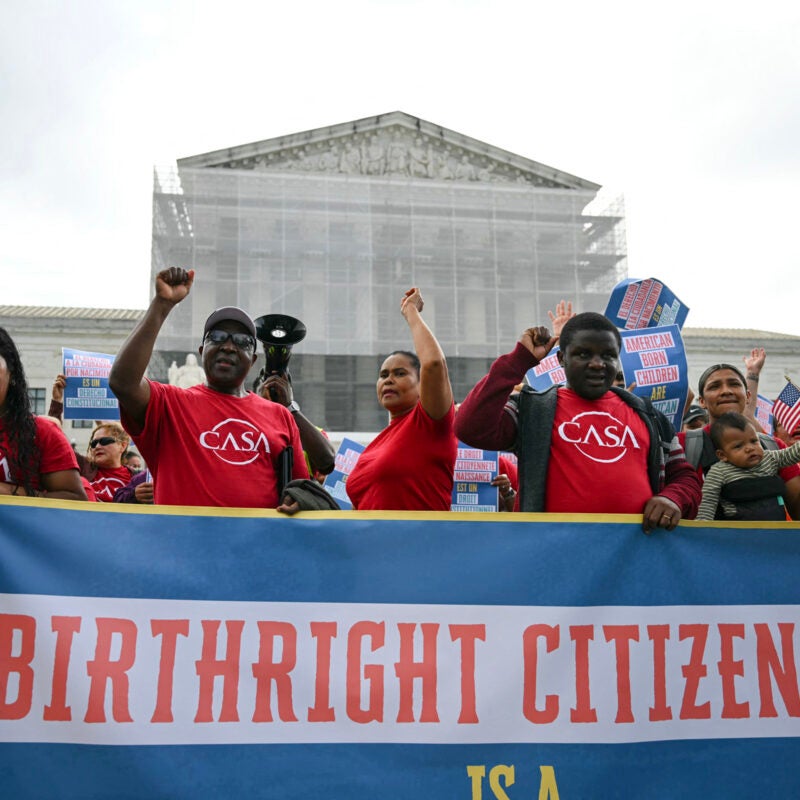 People holding a banner outside the Supreme Court.
