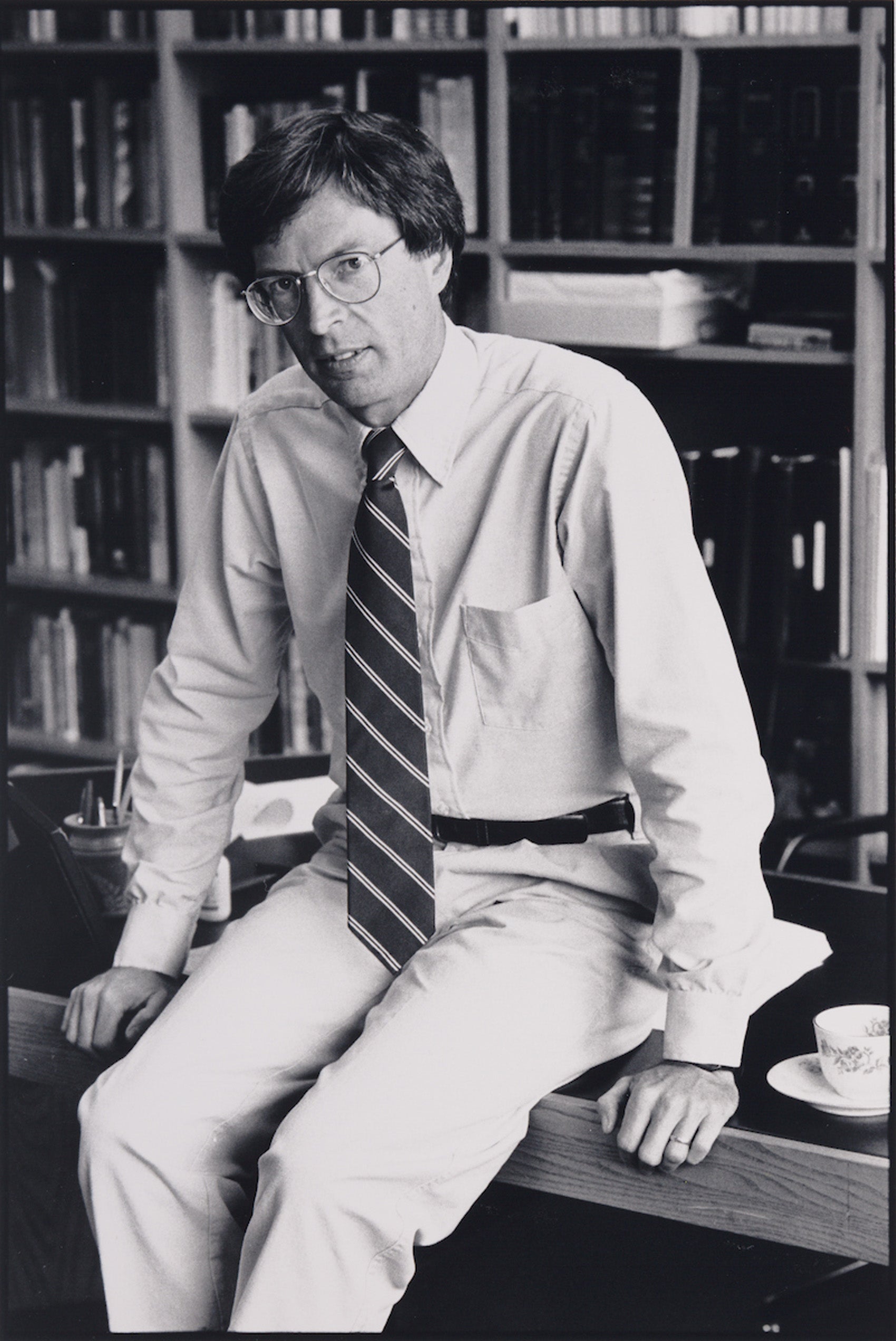 Richard Fallon sitting on his desk in his office.