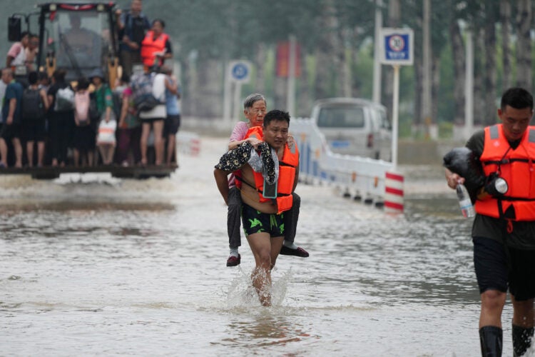 A villager being rescued from flooding.