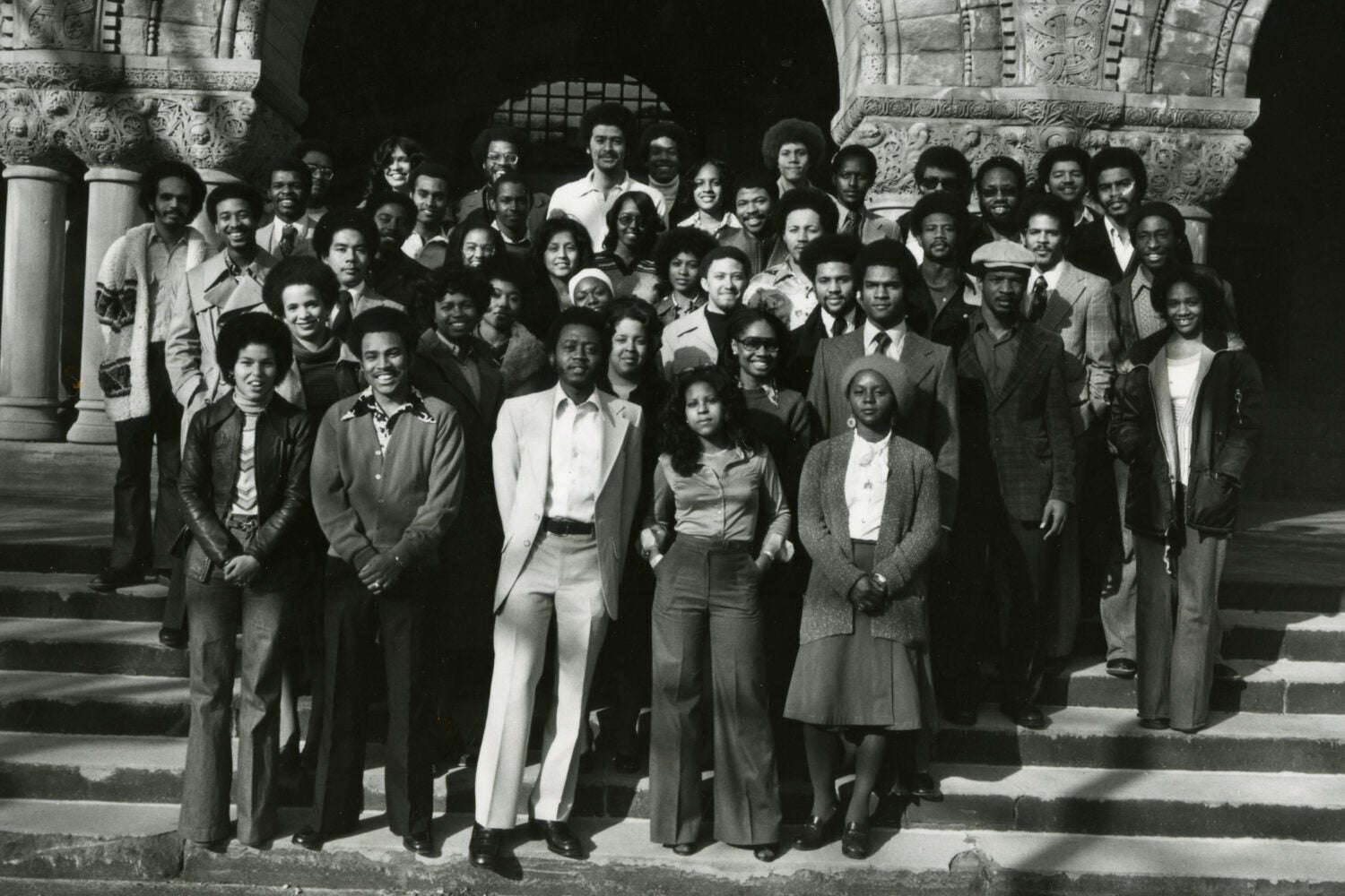 Full-length view of +/- 45 people standing on the steps of Austin Hall, Harvard Law School campus.