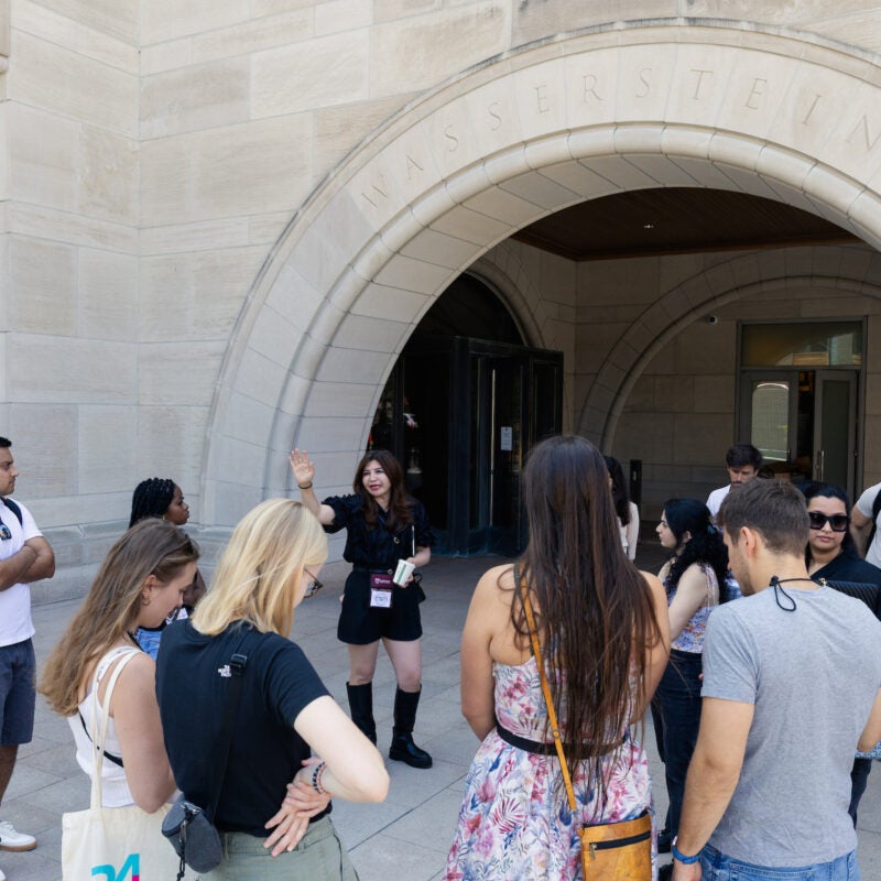 LL.M. students stop in front of a campus buidling during their tour of campus.