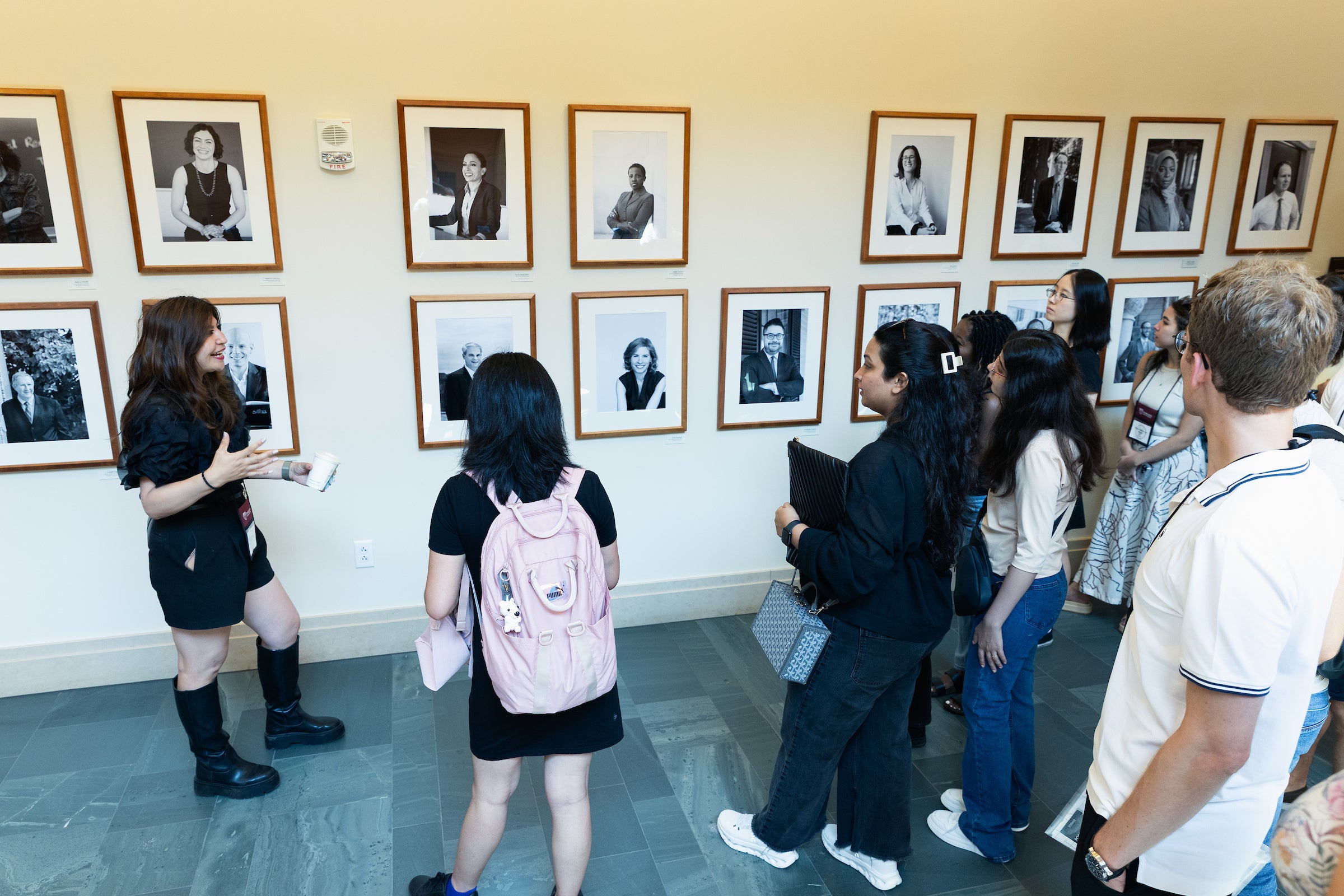 LL.M. students gather in front of Harvard Law School faculty portraits on display in the WCC during a tour of the school as part of orientation.