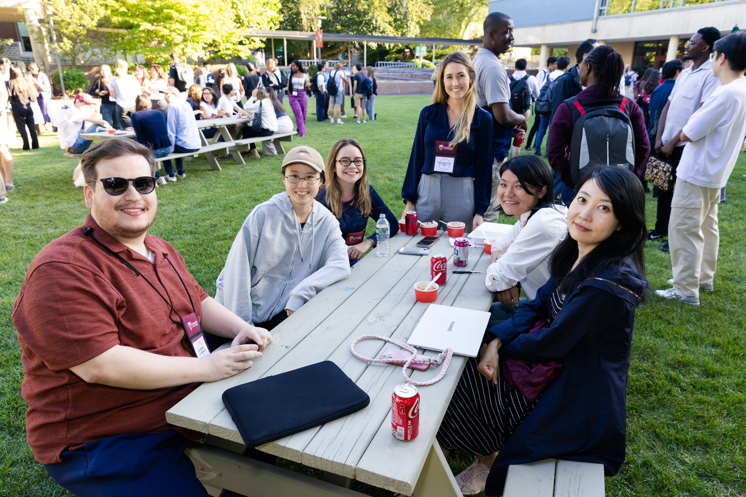 Students sitting at a picnic table enjoying ice cream at an orientation event.