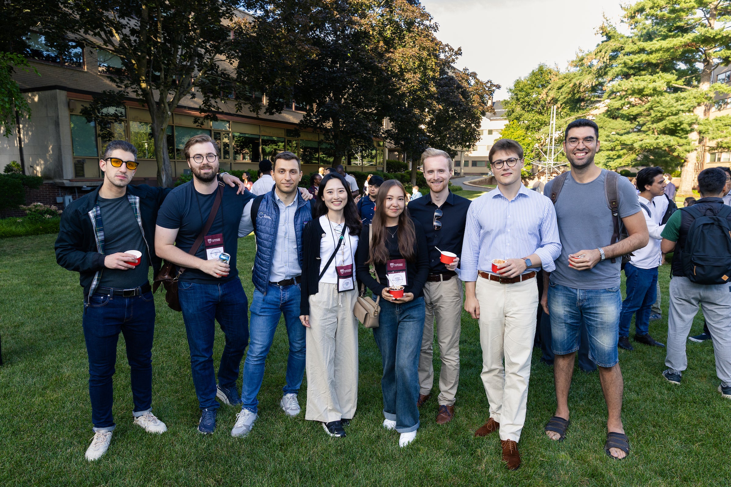 A group of graduate students pose on campus during an ice cream social.