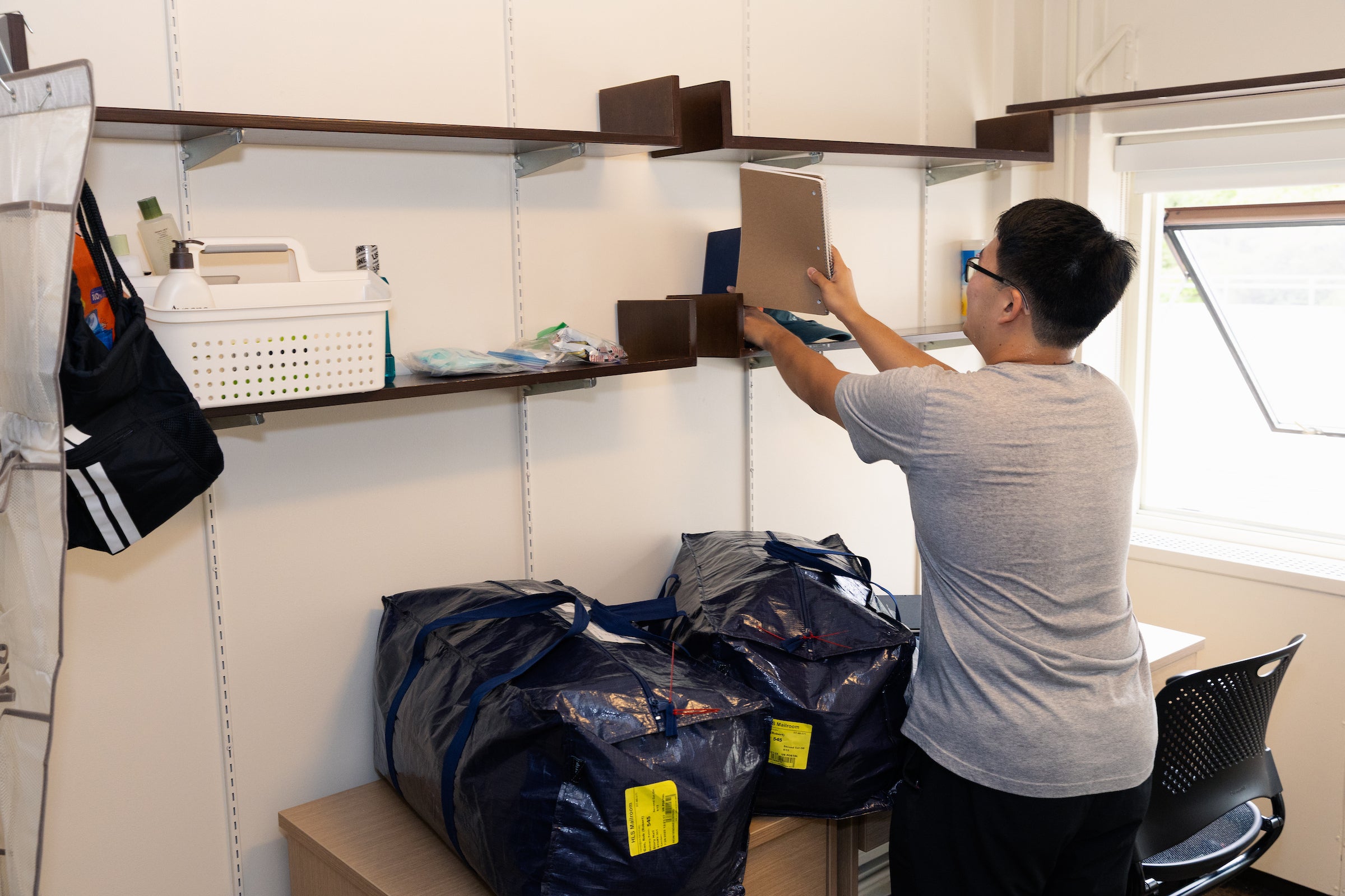 A student sets up his room during move in day.