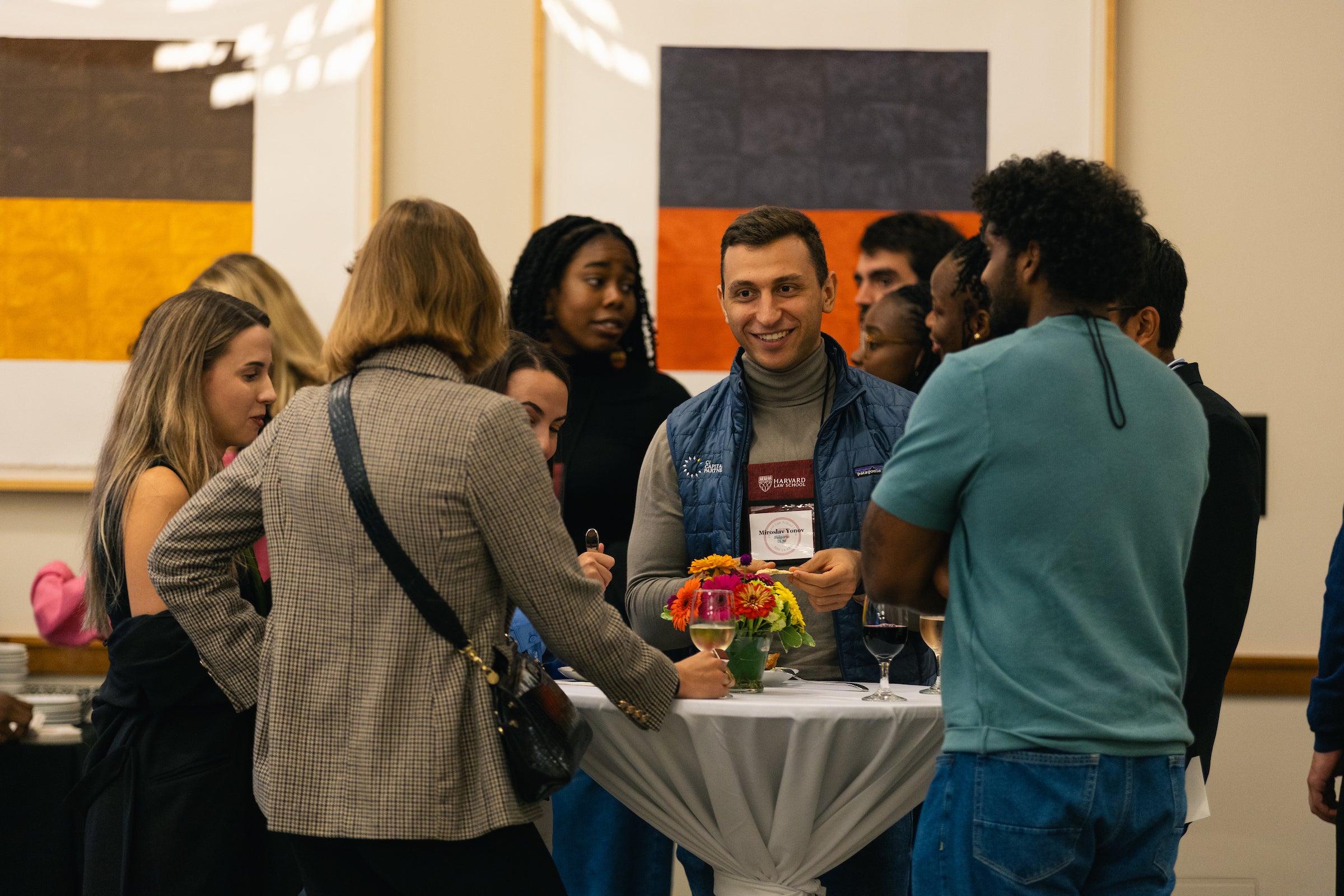 Students gather around a table during a reception for incoming LL.M. students.