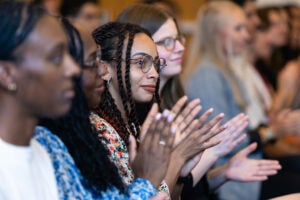 Attendees applaud at the First Class welcome reception.