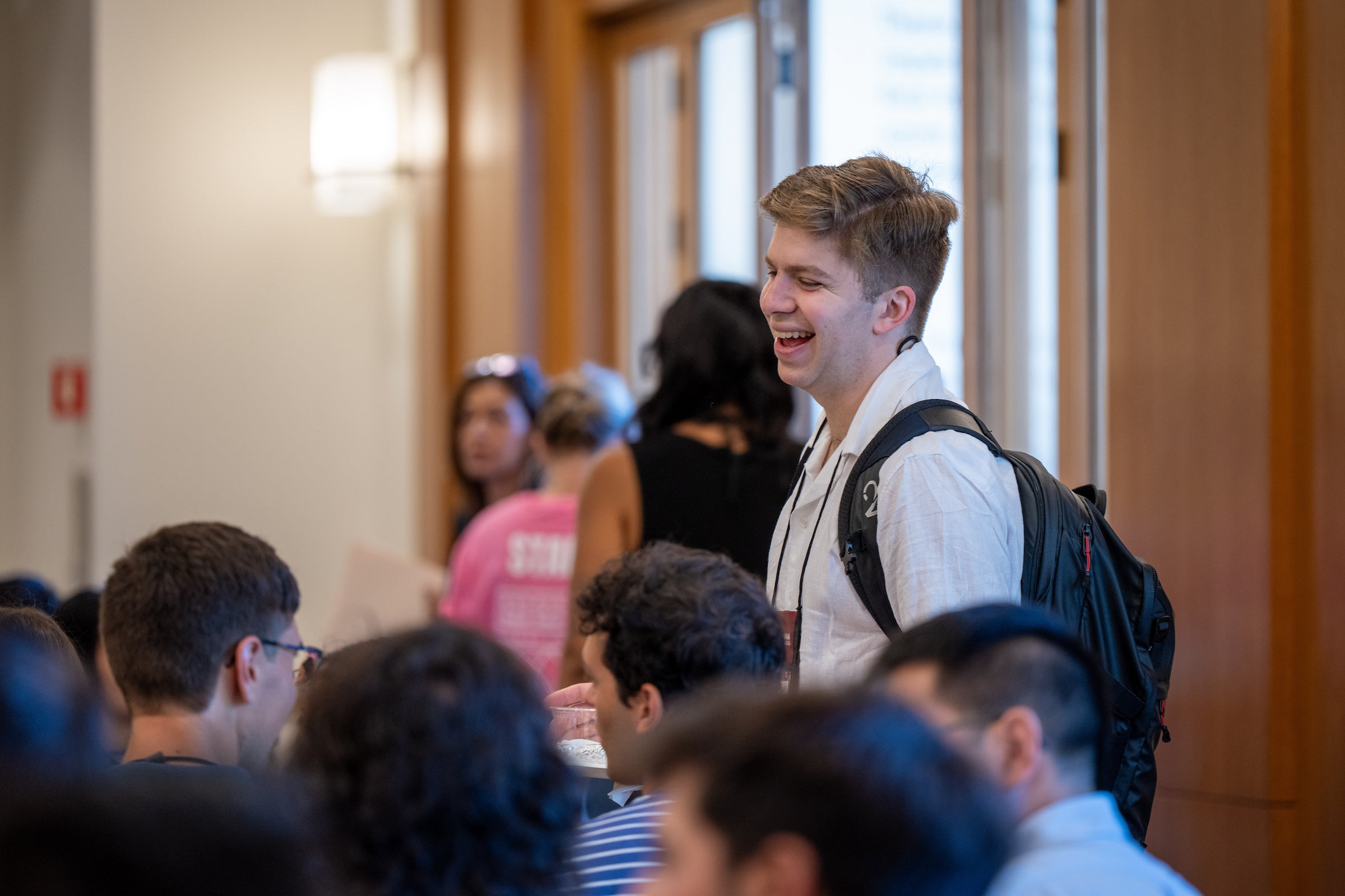 A student shares a light moment with classmates during an orientation event.