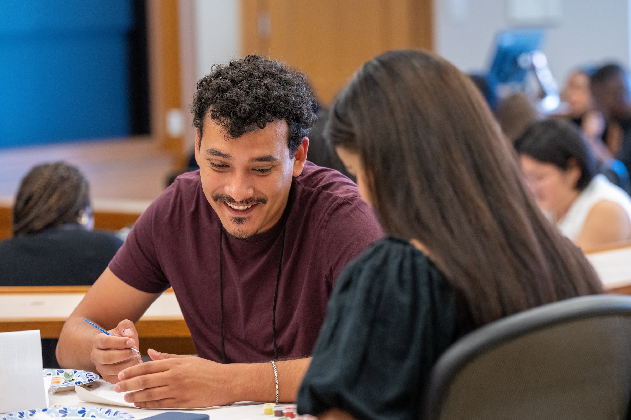 Two students chat as they take part in a painting activity during a pre-orientation event known as Day Zero.